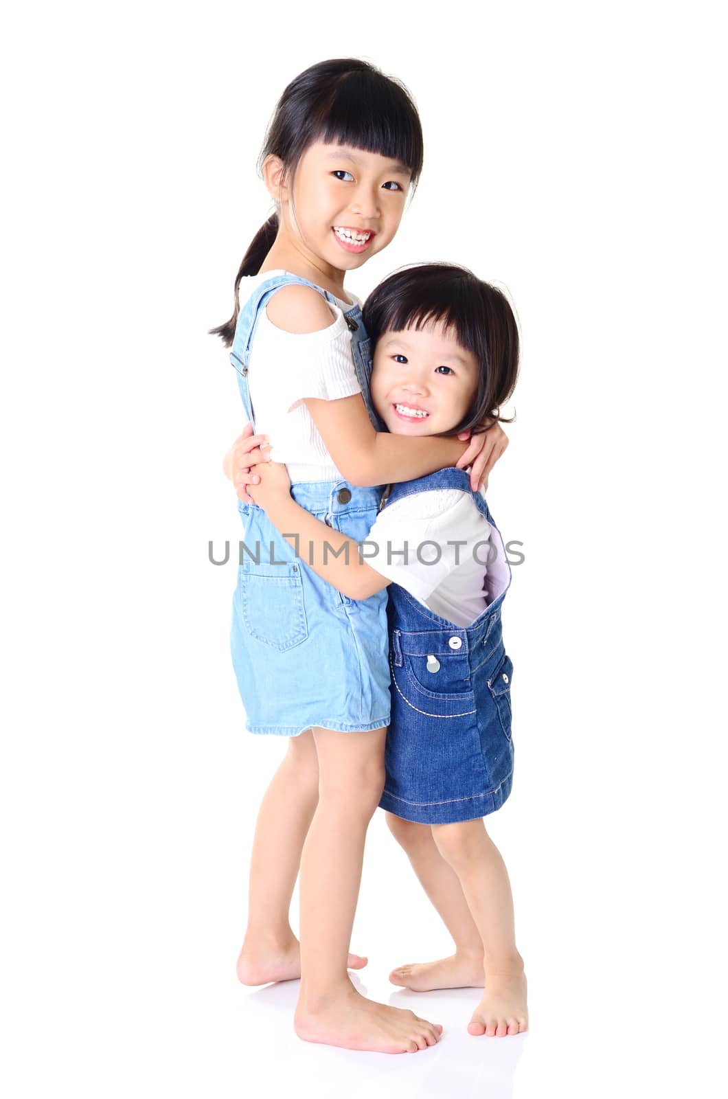 Portrait of young asian sisters with arms around each other smiling