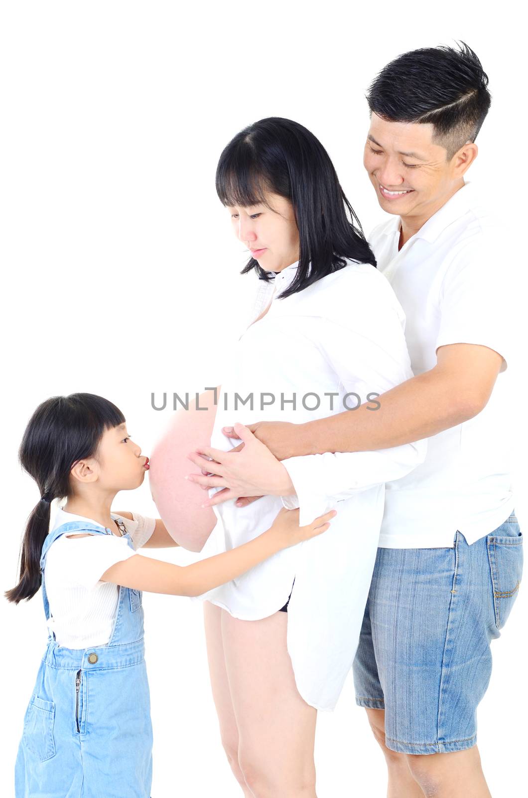 Little asian girl kissing her pregnant mother belly and smiles at home