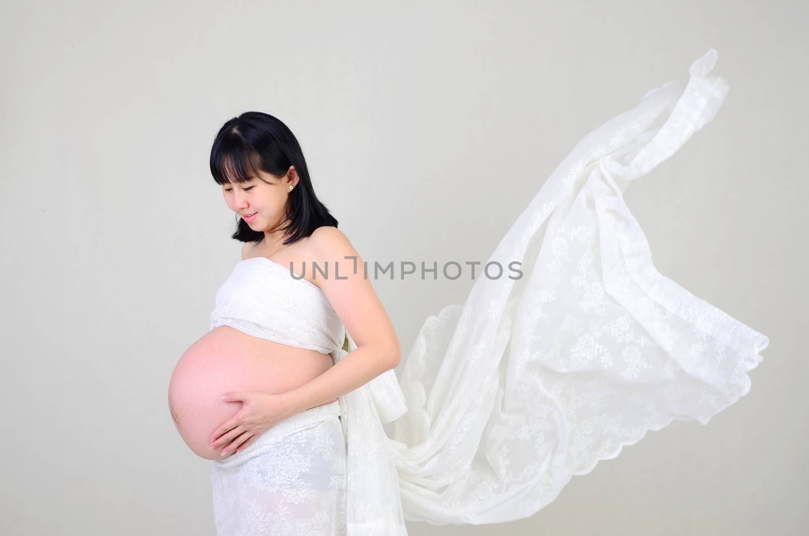 Asian pregnant woman holding her belly