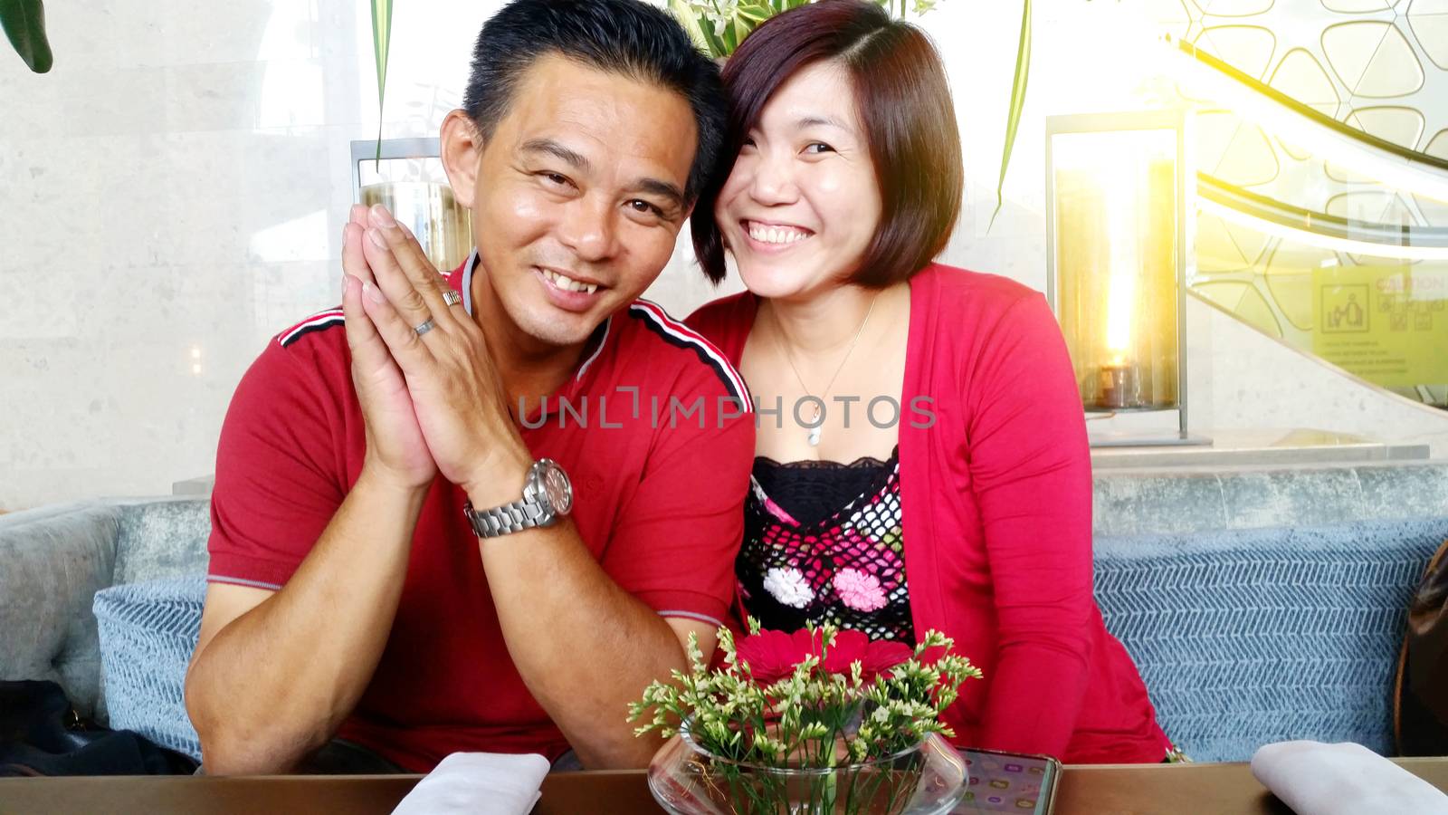 An Asian middle age attractive couple  sit in a beautiful cafe in the daytime.