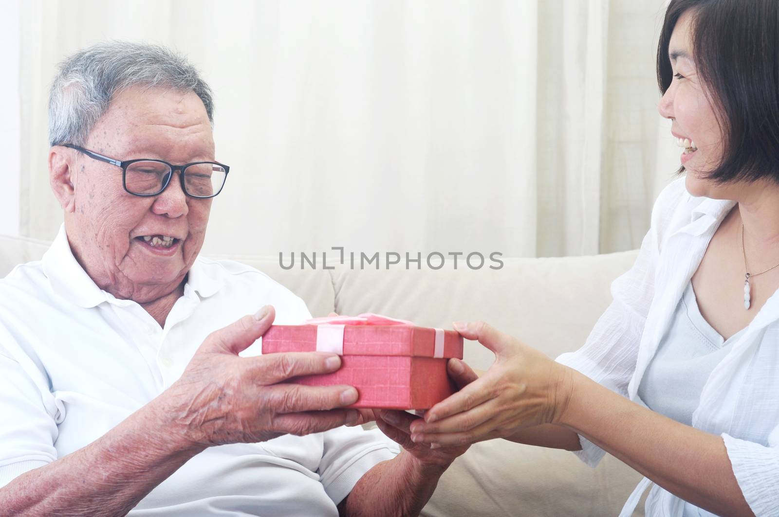 happy middle age woman gives a gift to her father