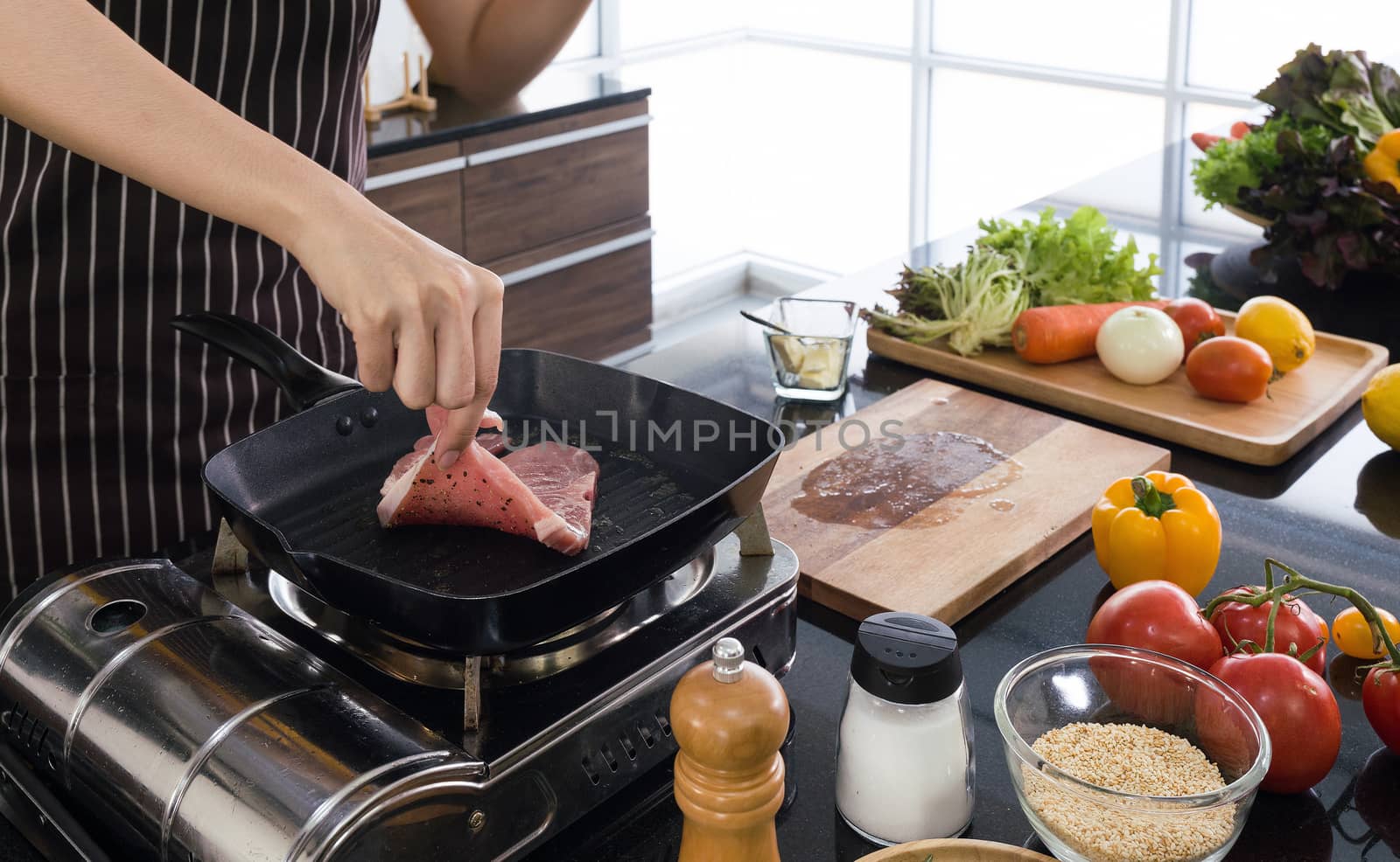 Housewives are frying steaks in the modern kitchen.