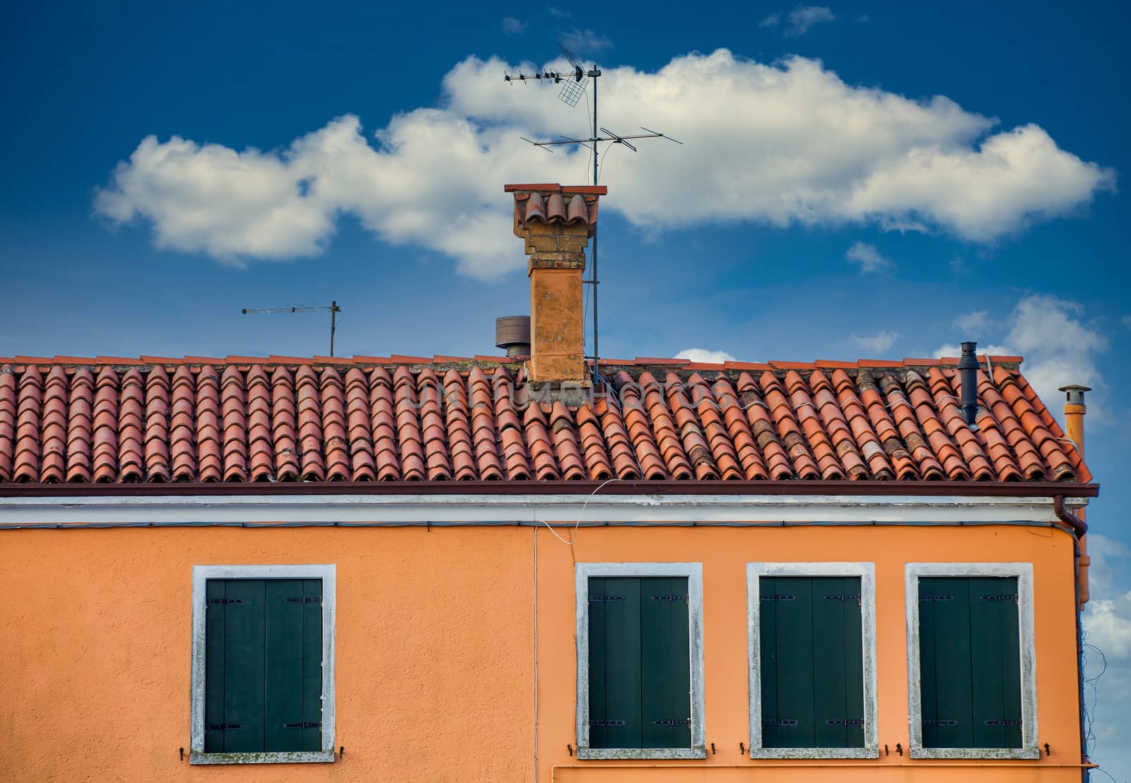 An old red tile roof on an orange plaster building in Venice