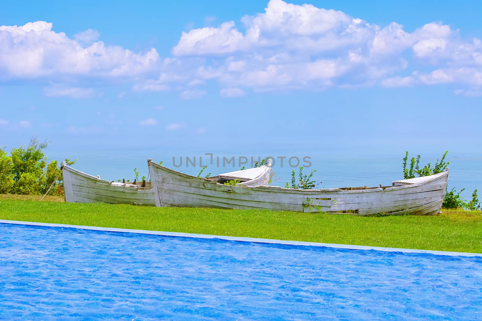 Two Old Boats between Swimming Pool and Sea