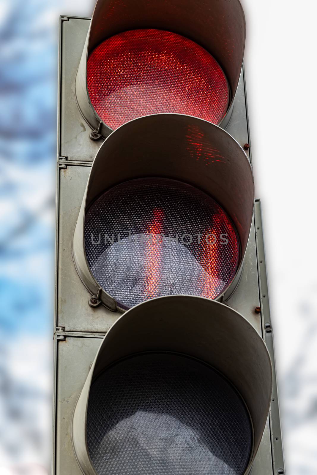 The traffic light shows red, which prohibits traffic for people. by bonilook