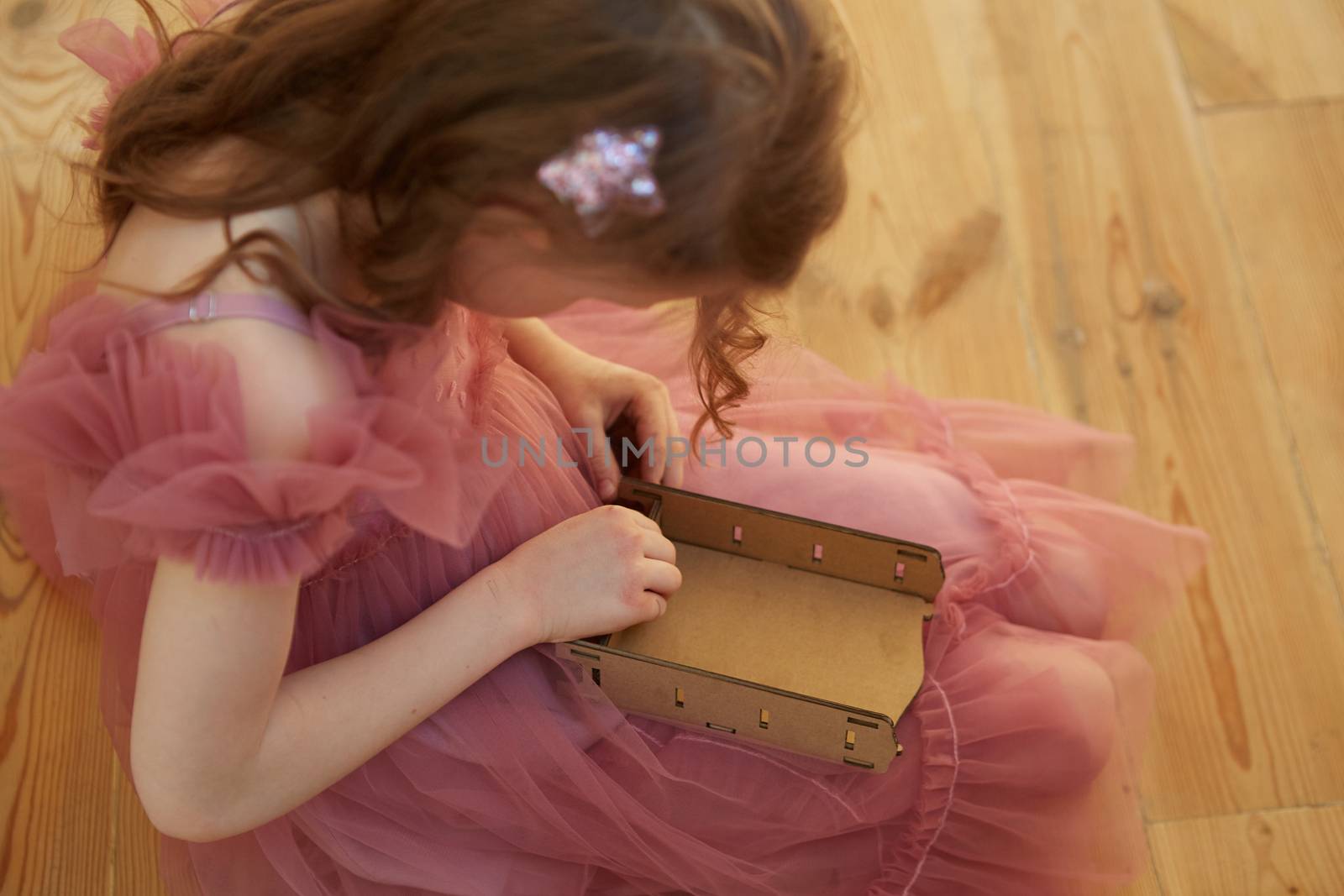 A girl playing with Cardboard Toy Dollhouse Furniture. by sarymsakov