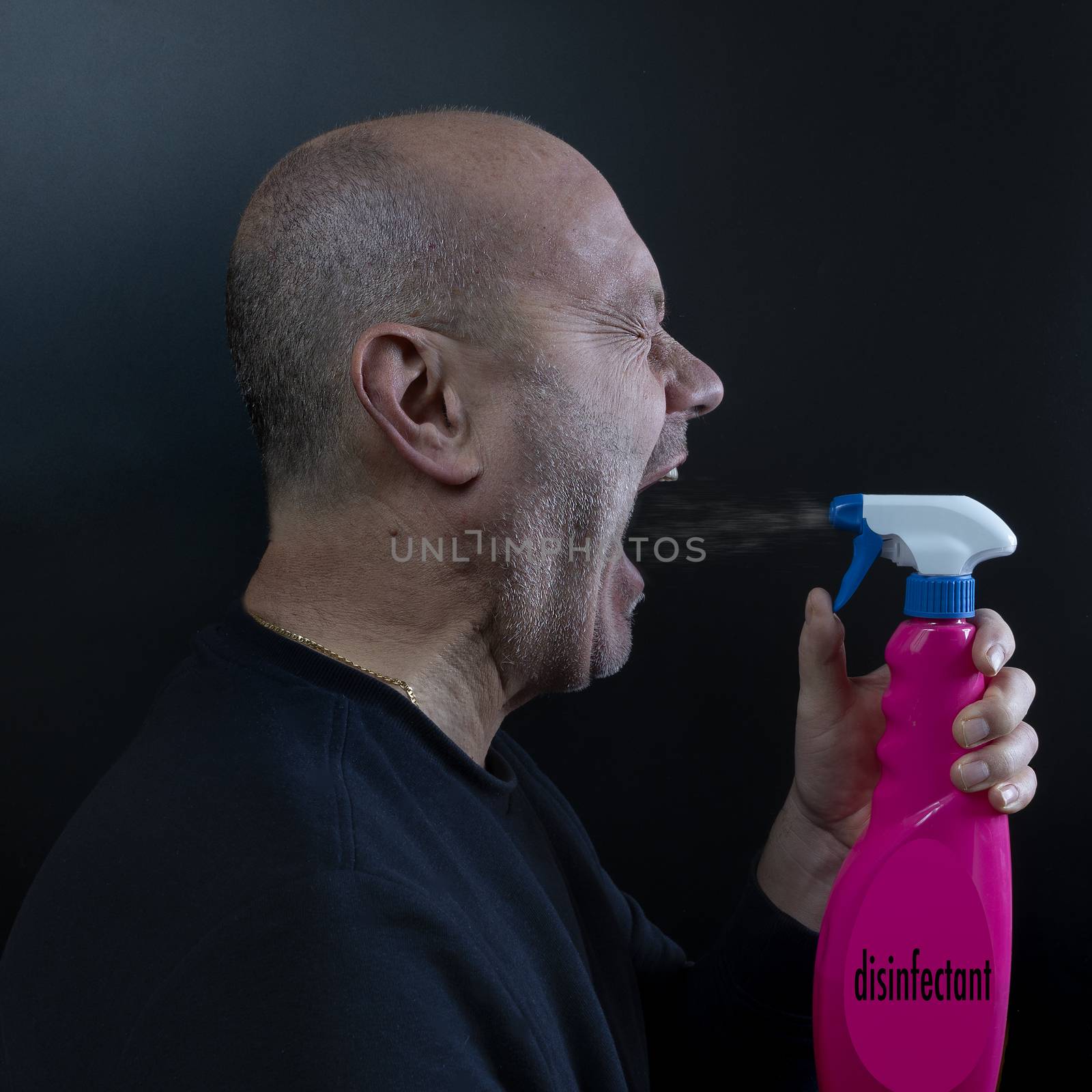 a man disinfects his mouth with a spray bottle