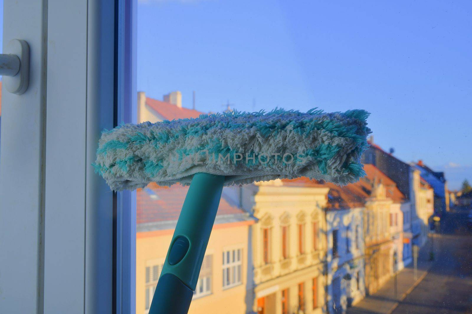 Cleaning windows with a squeegee. Cleaning concept. Washing window, close up. by roman_nerud