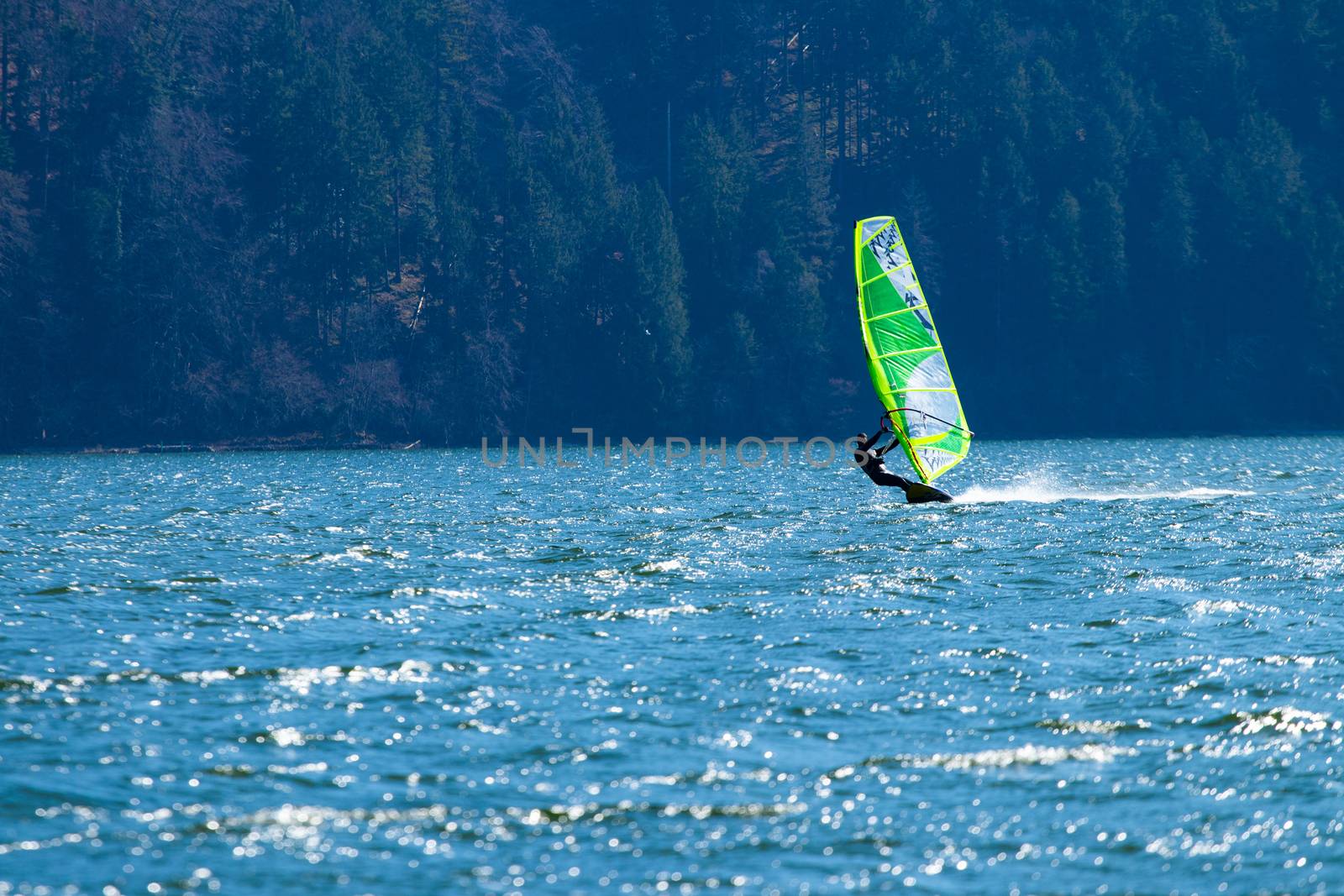 Lifestyle windsurfer on lake Alpnach in Switzerland during a windy spring day