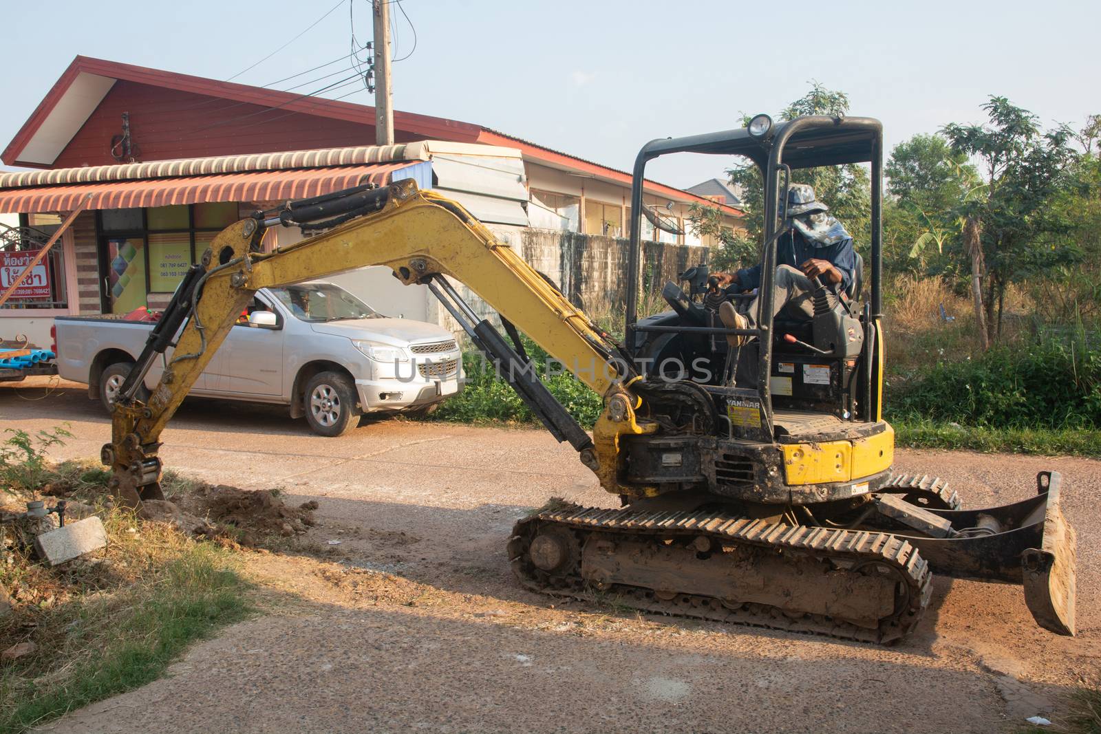 Yellow excavator machine working earth moving works at construction site
