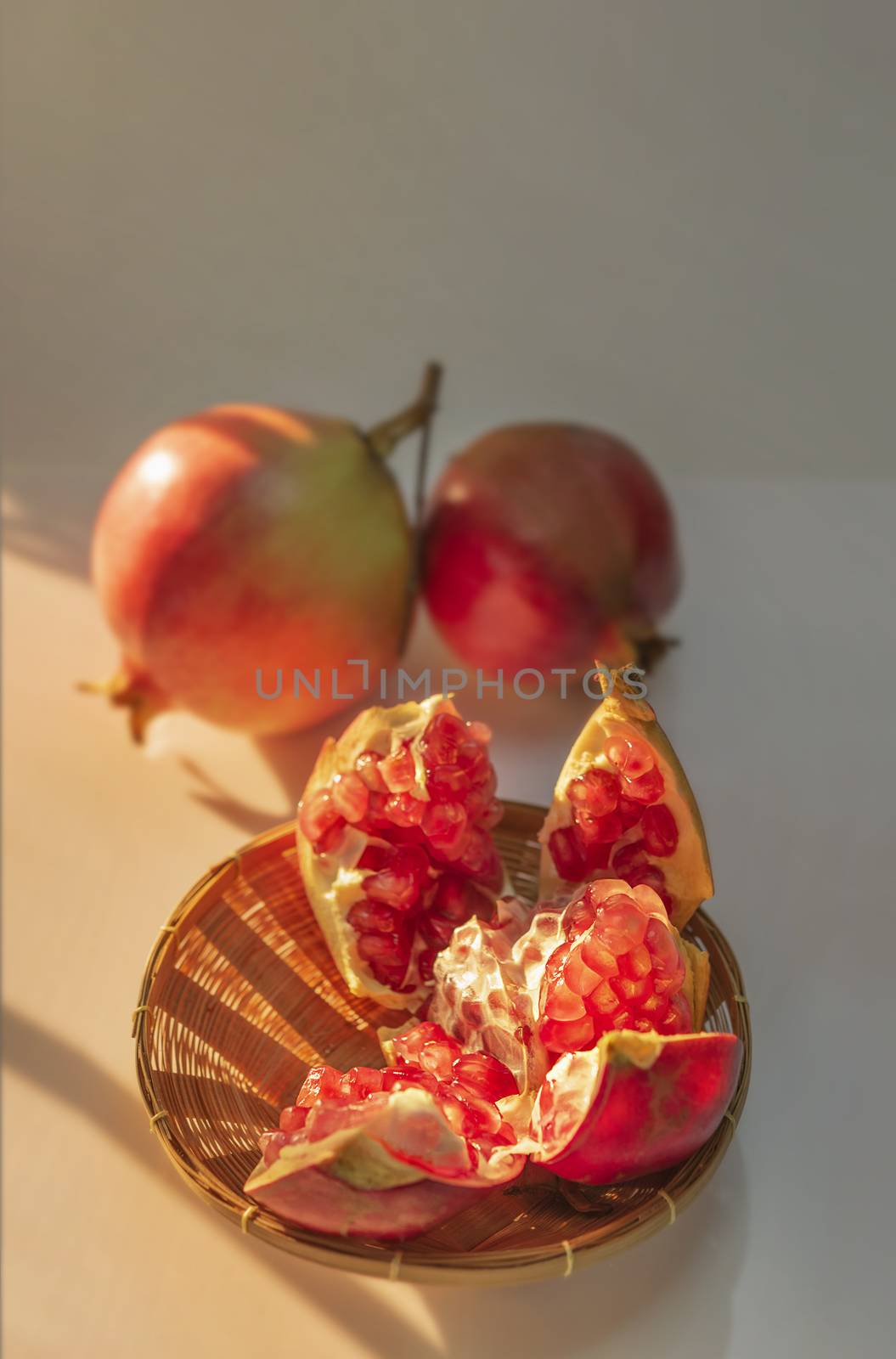 Pomegranate Fruit and wooden basket with sunlight