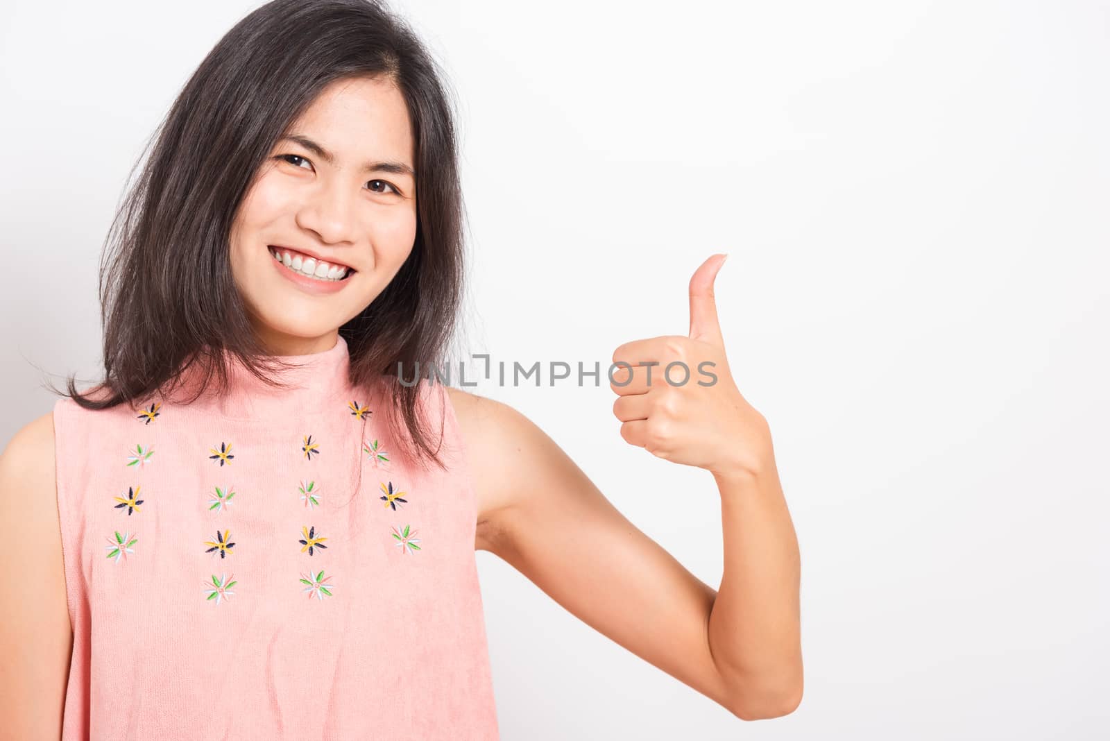 Portrait Asian beautiful young woman standing, She made finger thumbs up, Ok sign to agree and looking at camera, shoot photo in studio on white background, There was copy space