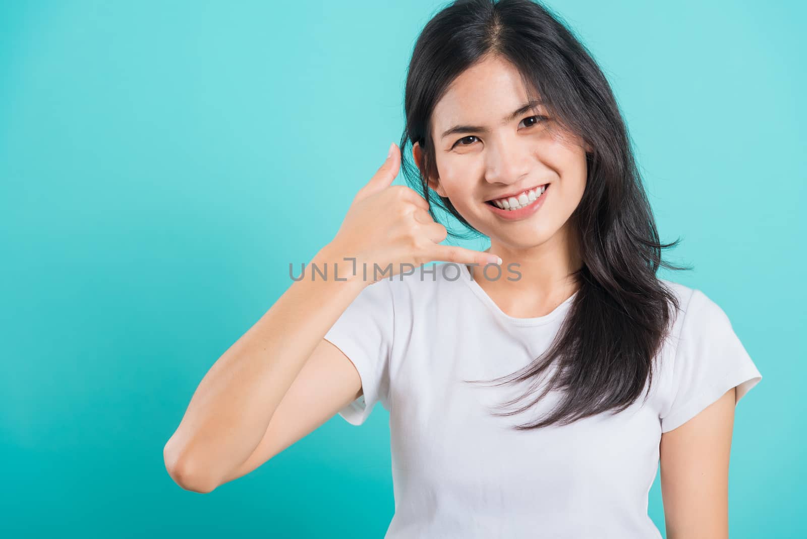Woman wear white t-shirt smile white teeth, making call me gestu by Sorapop
