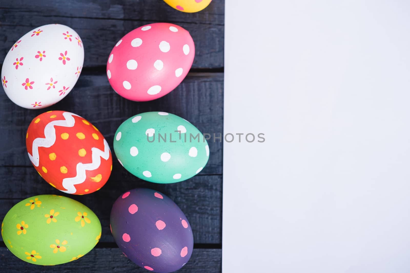 Easter eggs top view on black wooden background have white paper and copy space for use