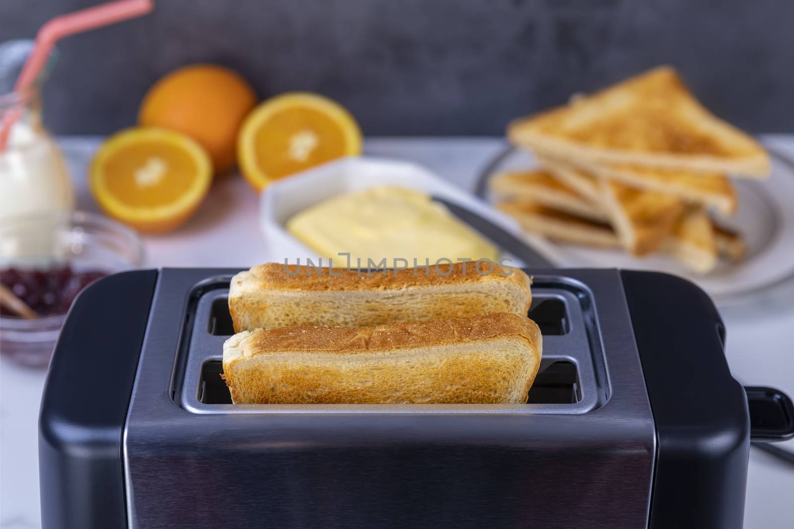 Slices of great toast coming out of the toaster. Healthy breakfast food and heating technology concept.  Focus on slice of great.