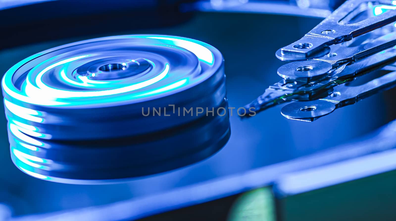 Detail of the inside of a hard disk with the reading head in operation, blue light image