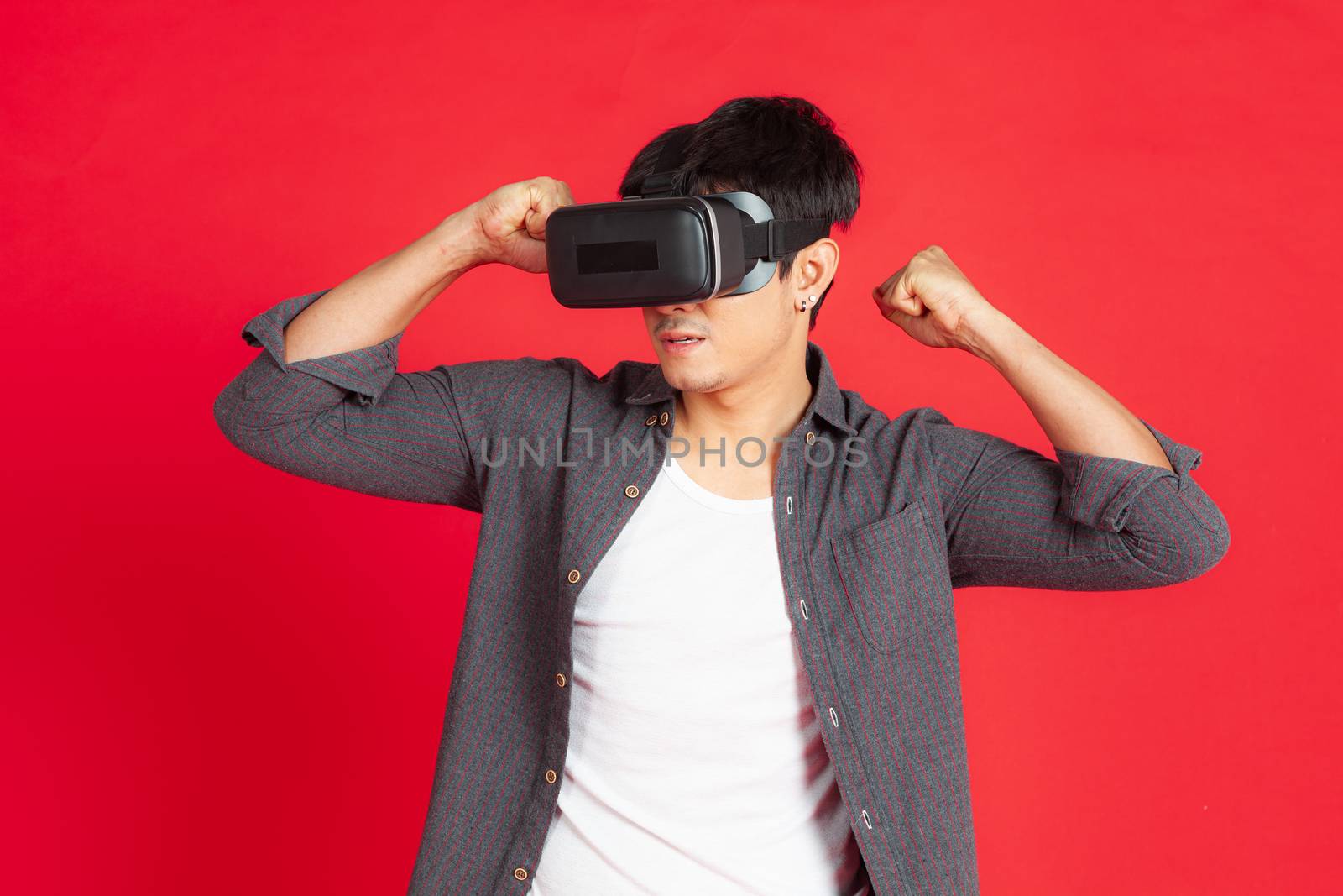 Young Man Wearing VR Headset and exploring another world isolated on red background