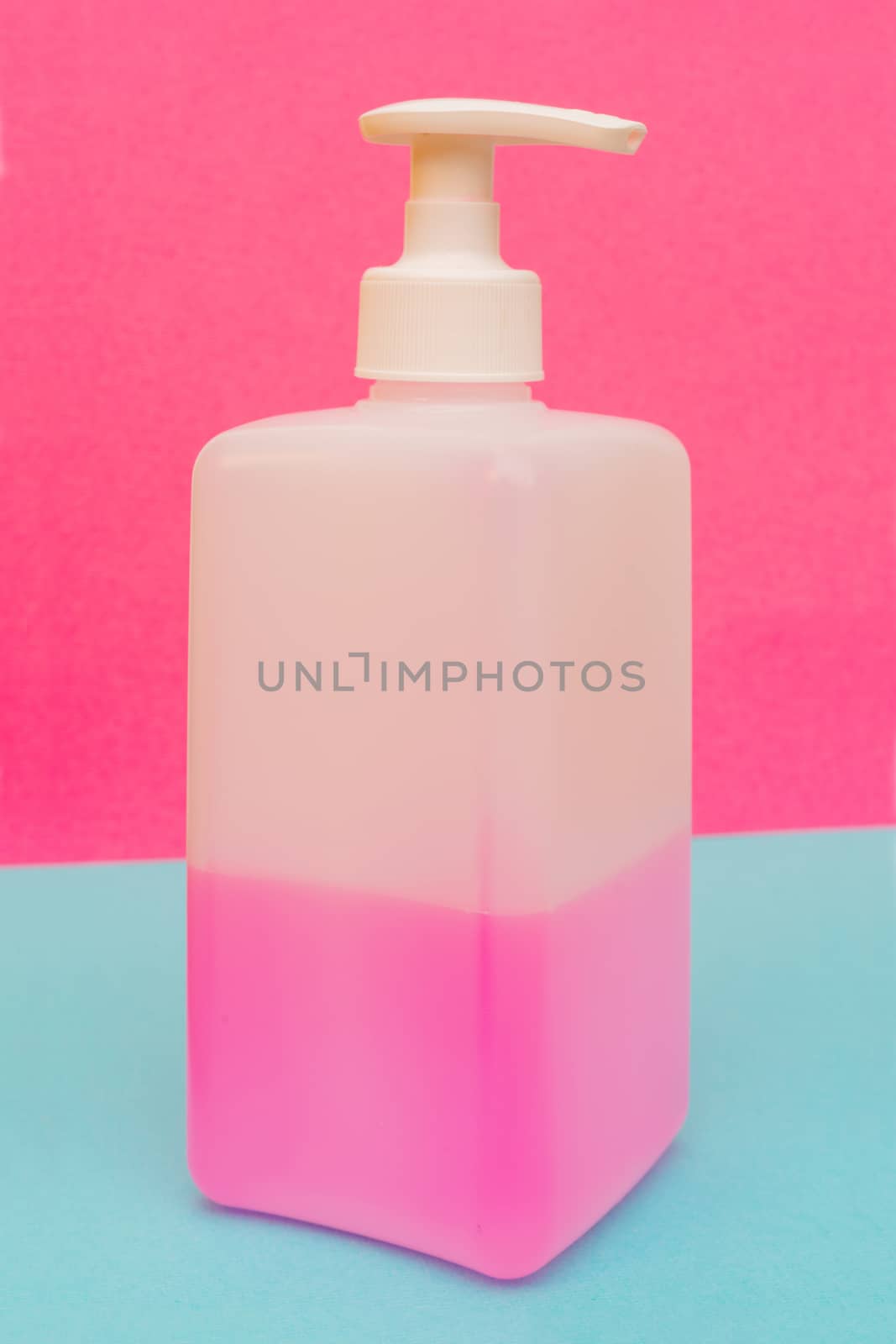 Antibacterial disinfectant soap. Liquid pink soap in white bottle.