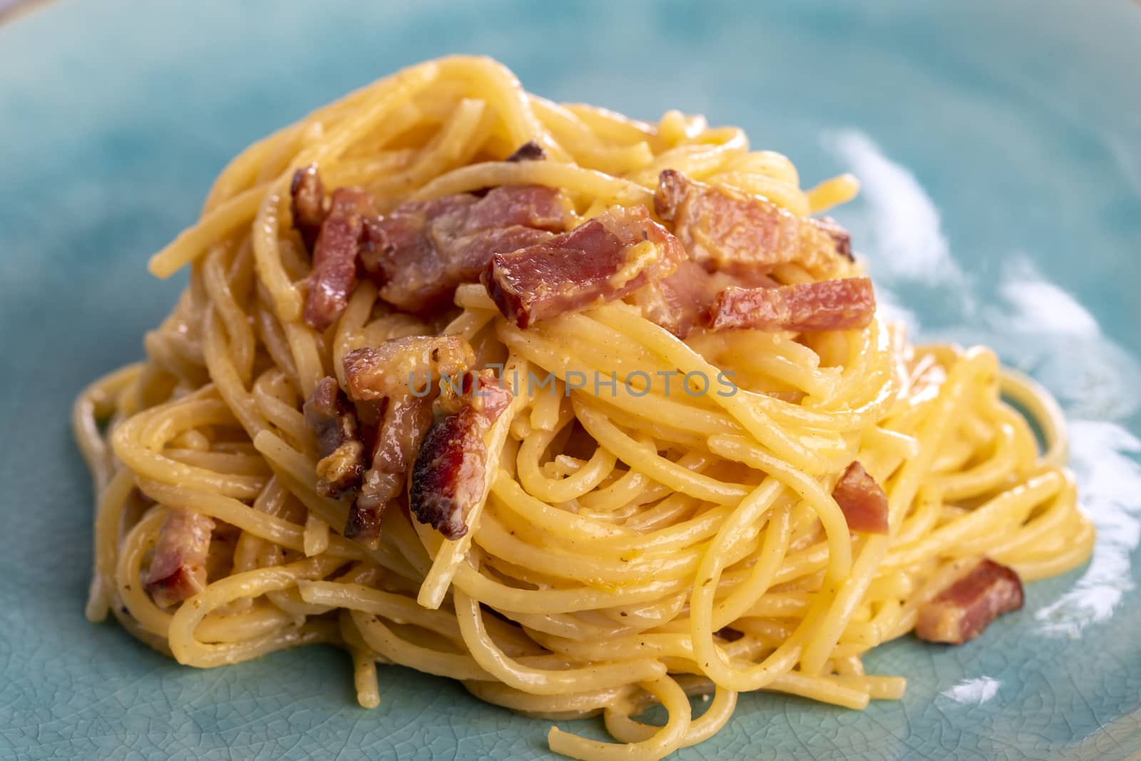 spaghetti carbonara on a blue plate