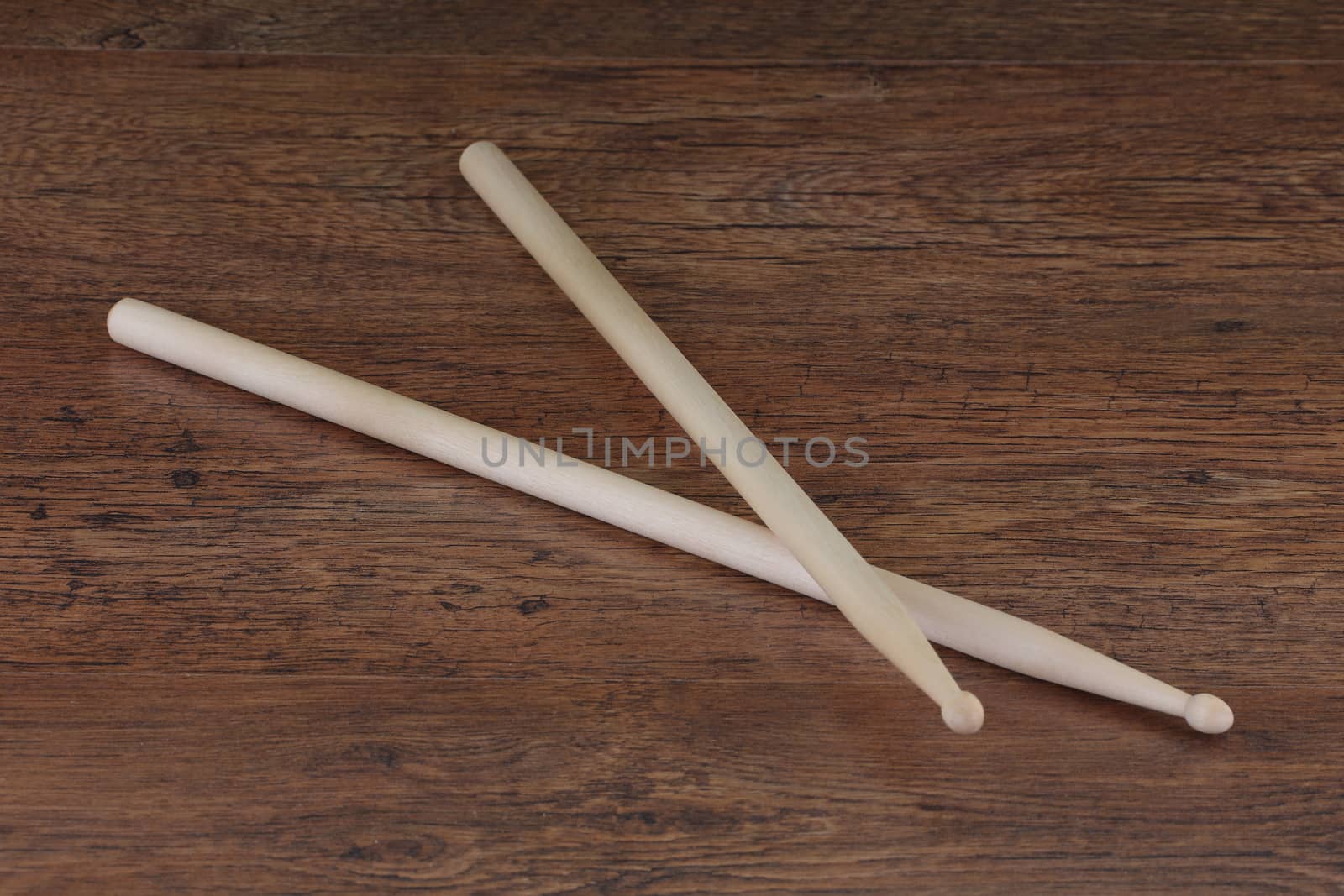 pair of drum sticks on wood surface by VivacityImages