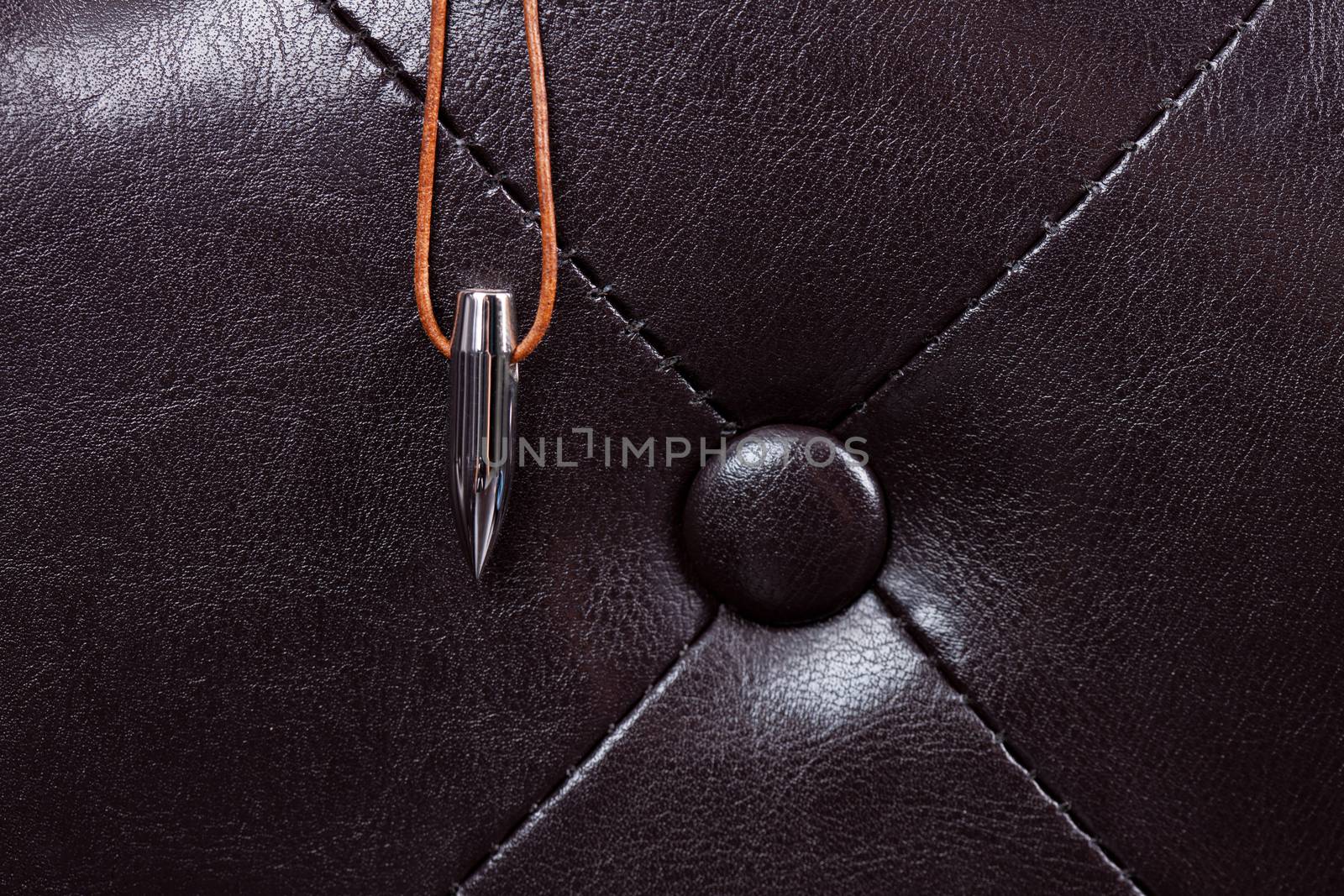 bullet lucky charm on leather couch with dark background
