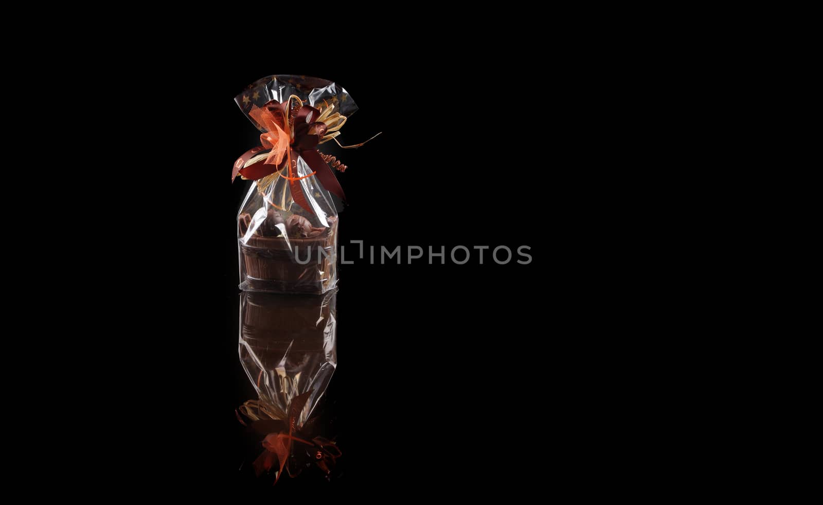 sweets in plastic food packaging with reflection and copy space on black background