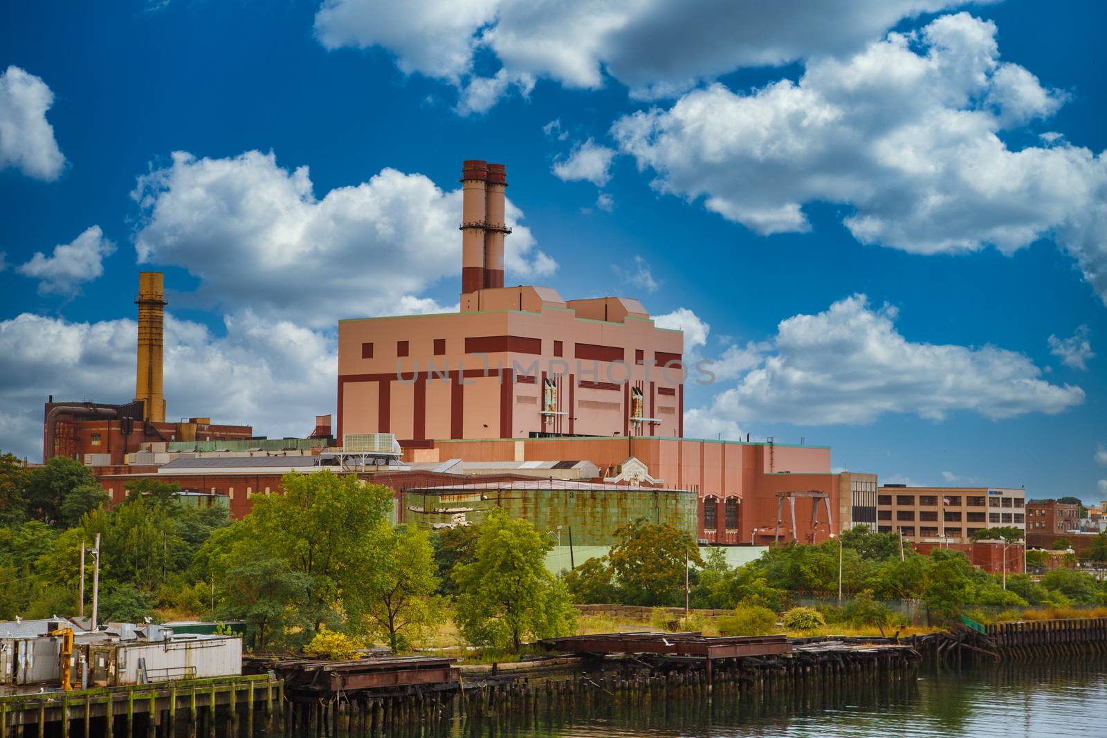 An old red brick industrial plant on the edge of a canal or river