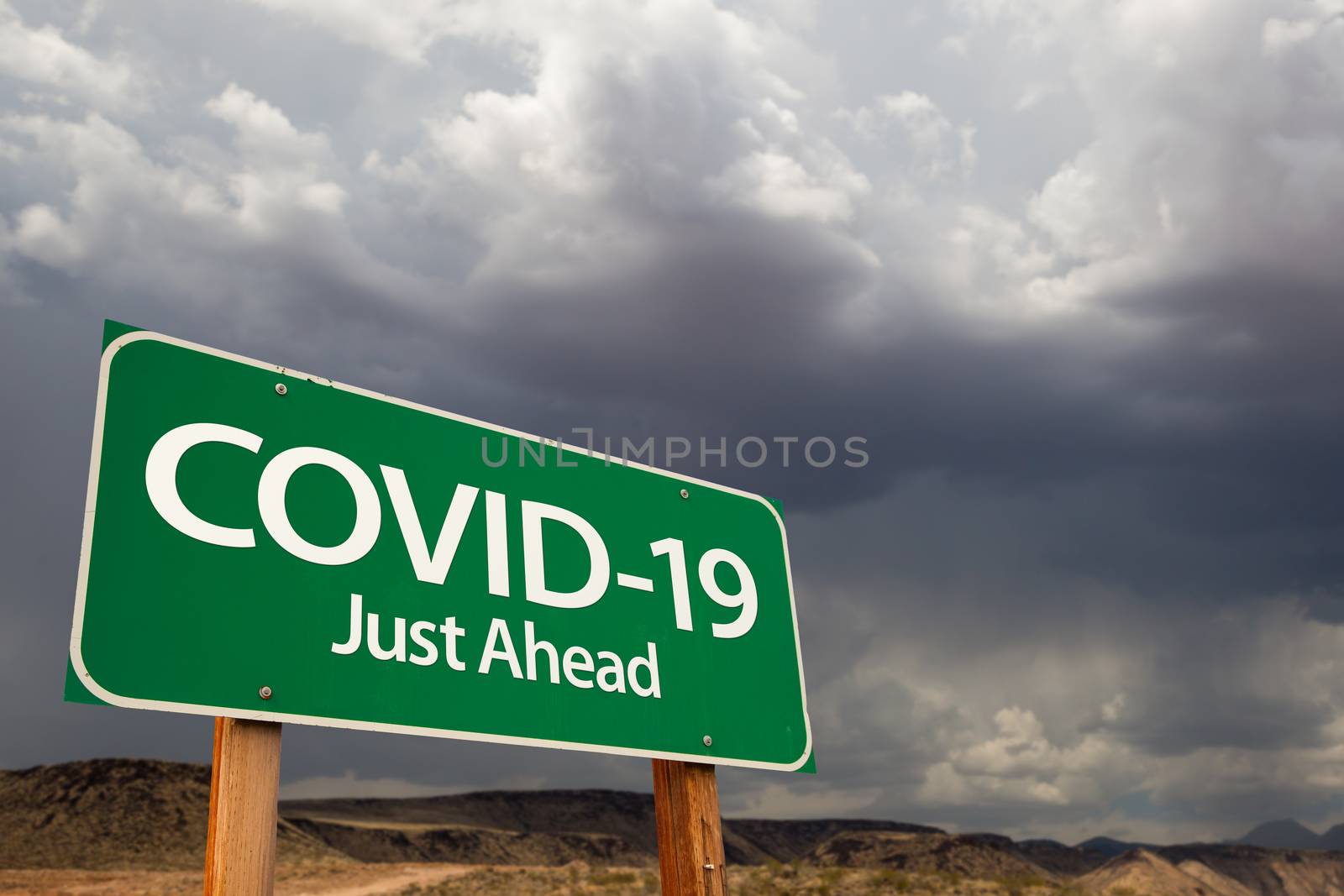 COVID-19 Coronavirus Green Road Sign Against Ominous Stormy Cloudy Sky.