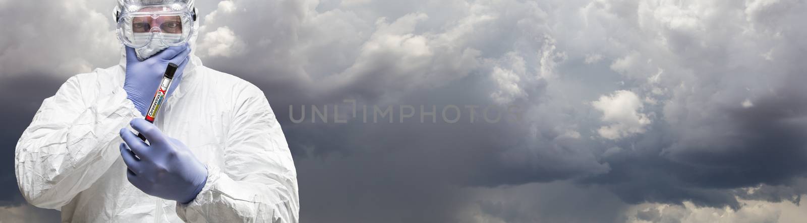 Male Doctor or Nurse In Hazmat Gear Holding Positive Coronavirus Test Tube Cloudy Sky Banner.