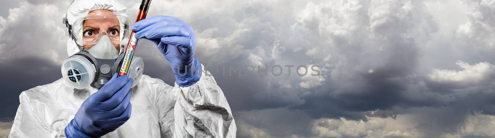 Female Doctor or Nurse In Hazmat Gear Holding Positive Coronavirus Test Tube Cloudy Sky Banner. by Feverpitched
