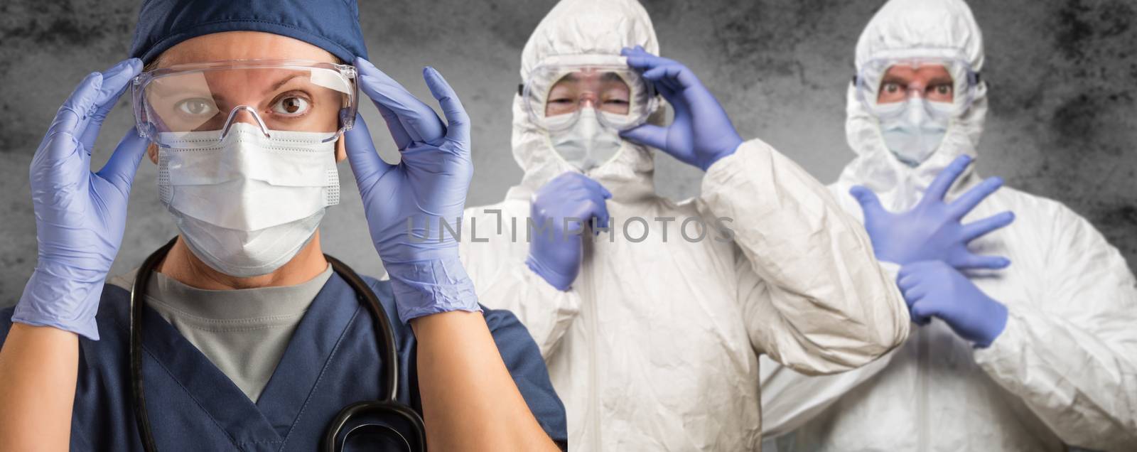 Caucasian Woman, Man and Chinese Man In Masks, Goggles and Hazmat Suites.