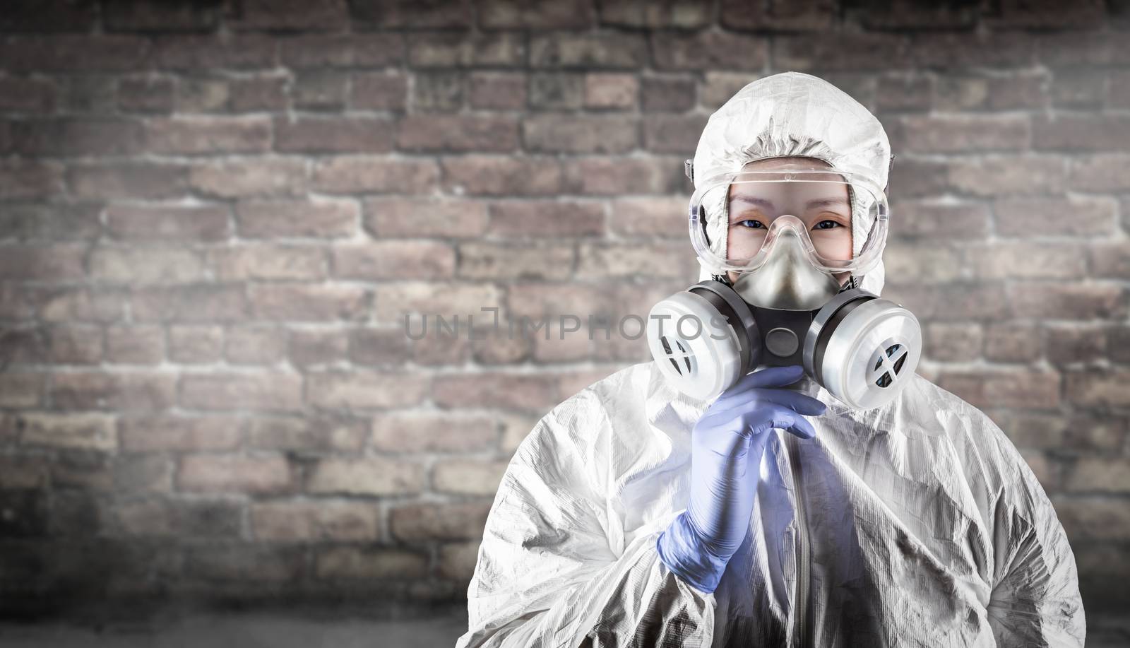 Chinese Woman Wearing Hazmat Suit, Protective Gas Mask and Goggles Against Brick Wall.