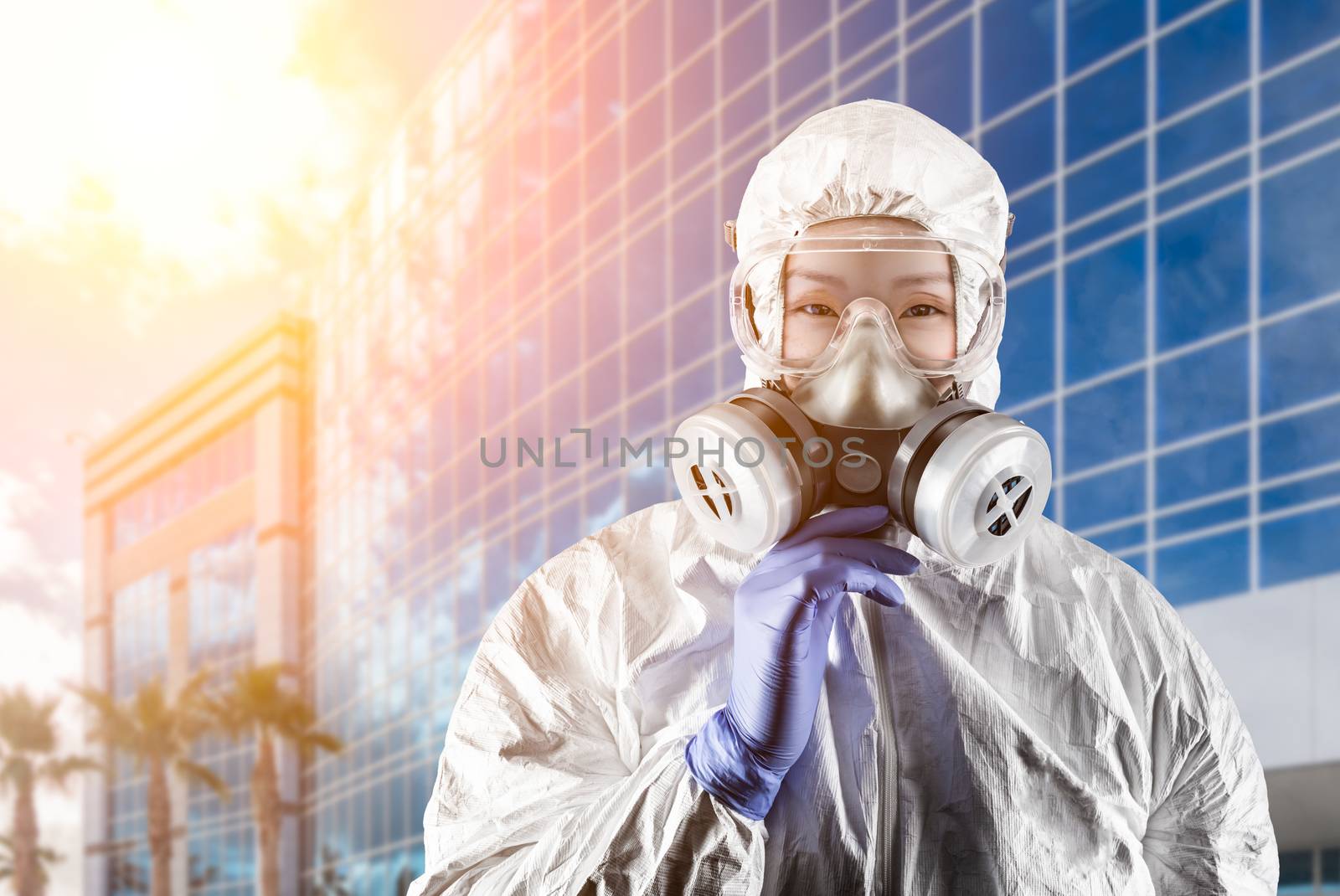 Chinese Woman Wearing Hazmat Suit, Protective Gas Mask and Goggles In Front of City Building.