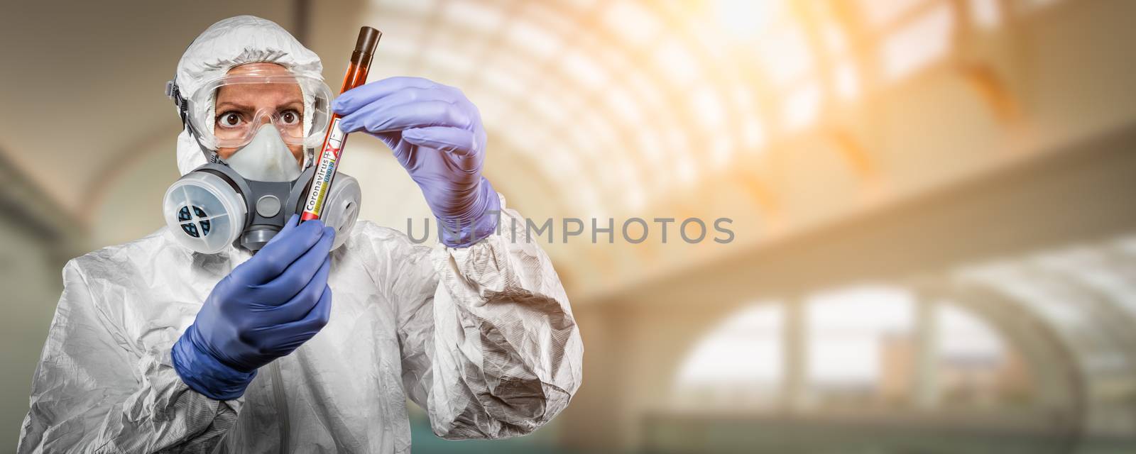 Female Doctor or Nurse In Hazmat Gear Holding Positive Coronavirus Test Tube Banner.