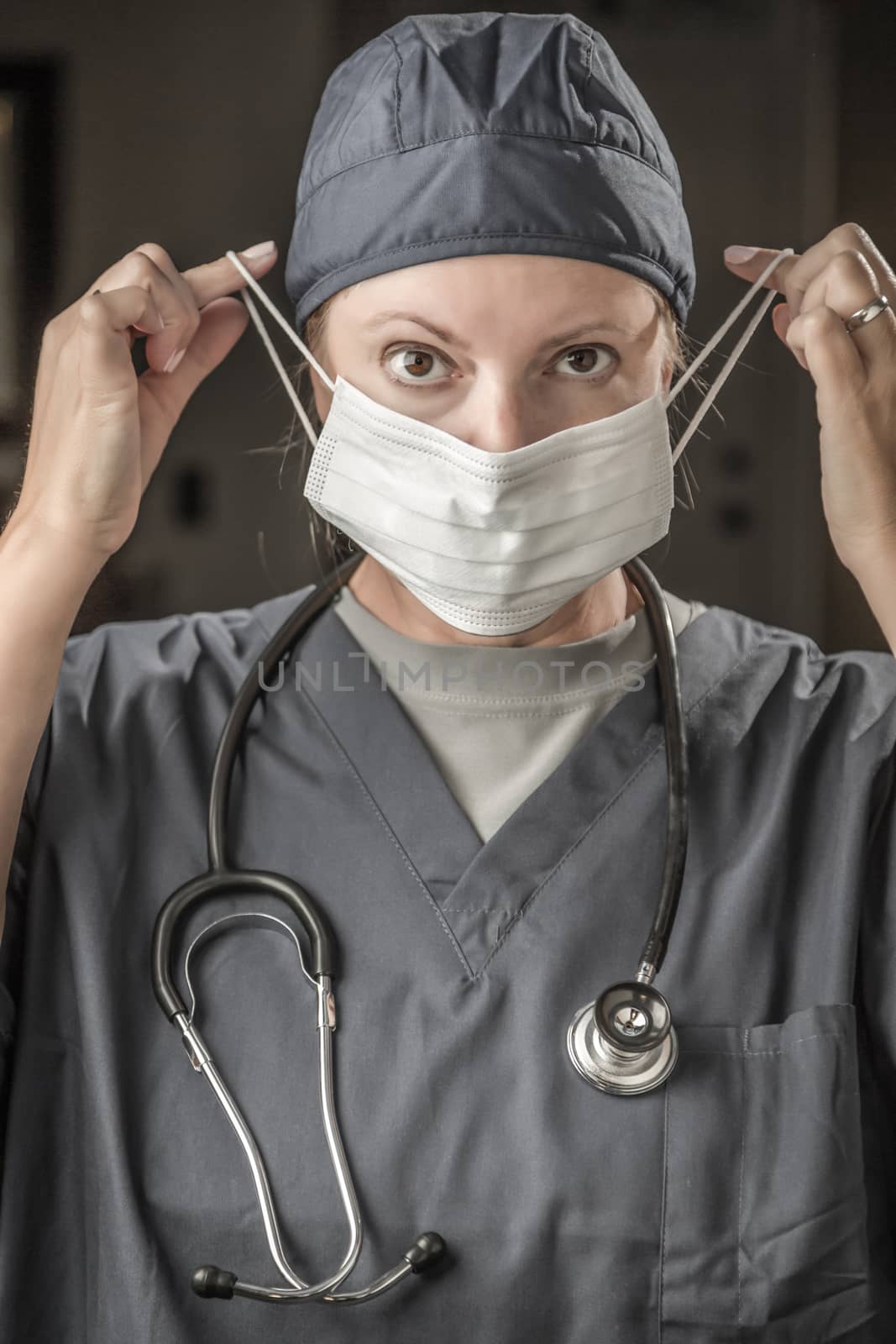 Female Doctor or Nurse with Stethoscope Putting On Protective Face Mask.
