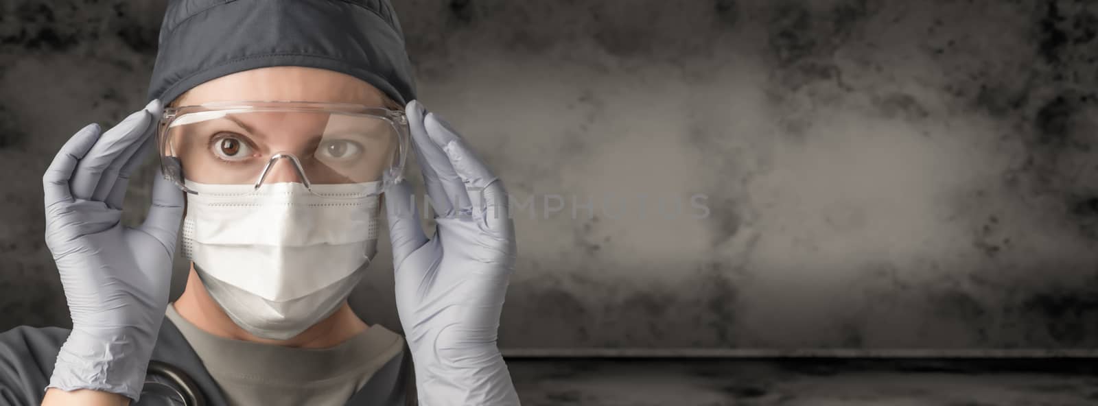 Female Doctor or Nurse Wearing Scrubs, Protective Face Mask and Goggles Banner. by Feverpitched