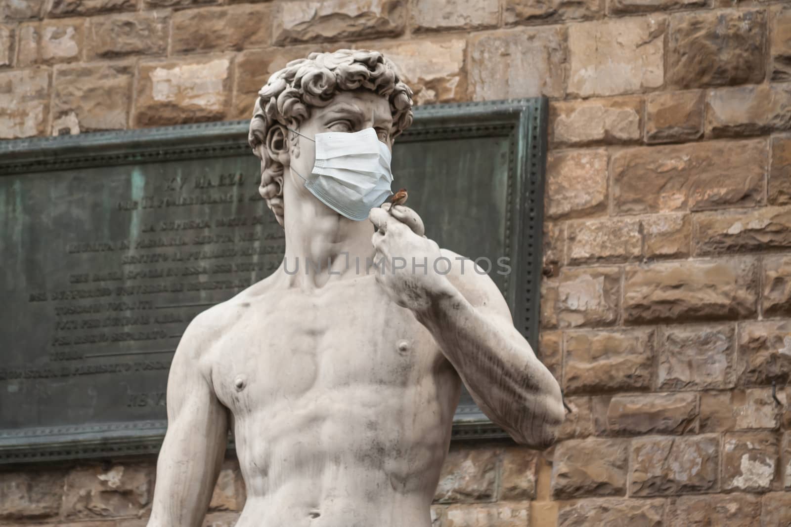 The Statue Of David in the Piazza della Signoria In Italy Wearing a Protective Face Mask.