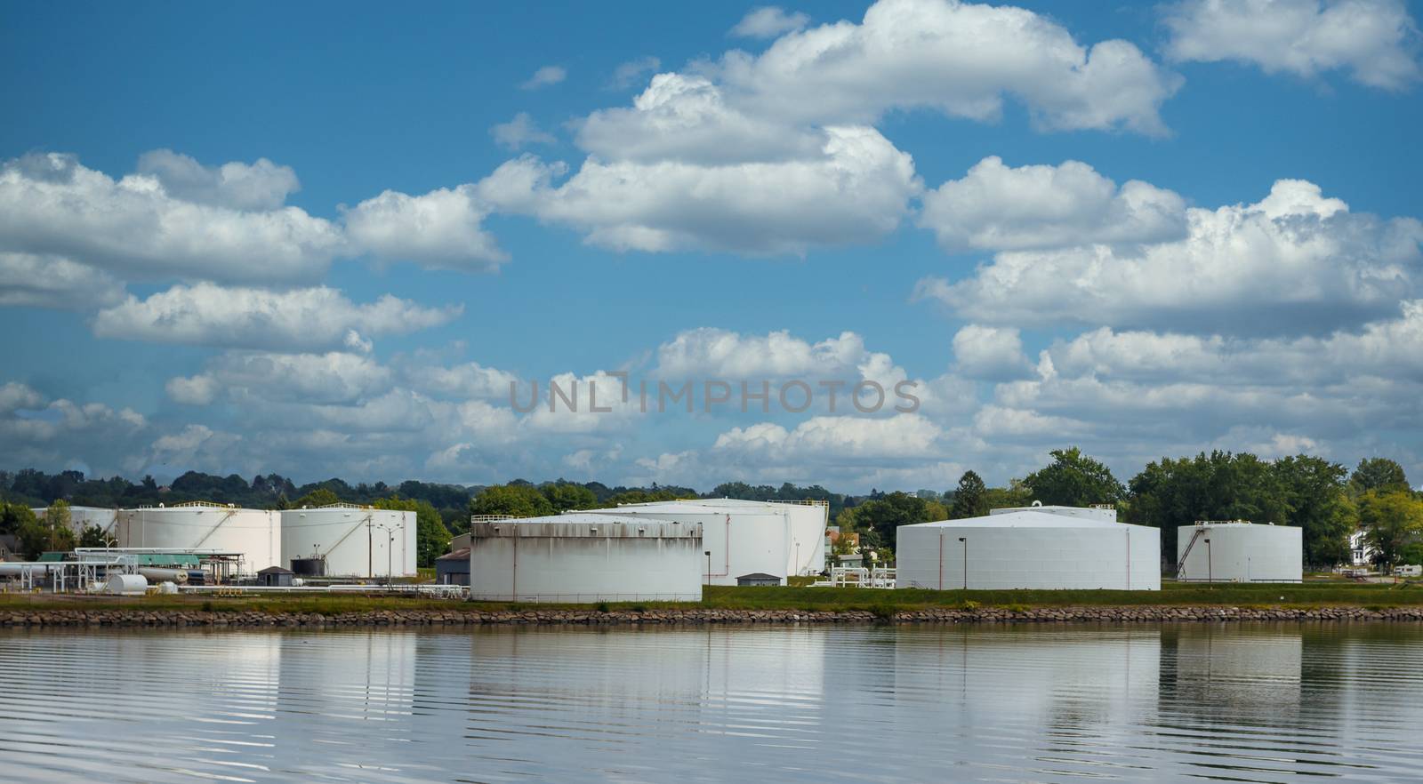 Old White Tanks on Shore of Calm Lake by dbvirago