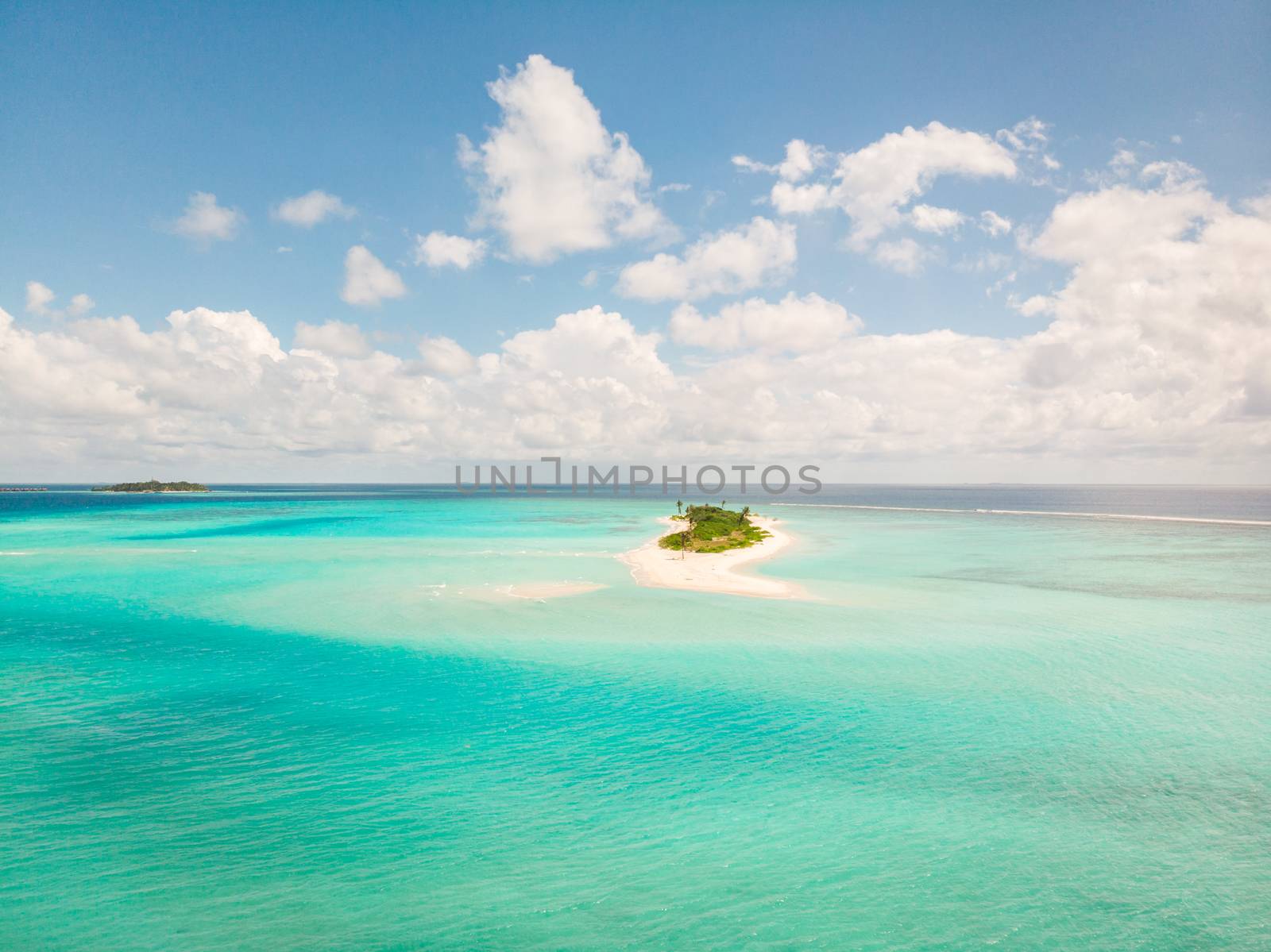Picture perfect beach and turquoise lagoon on small tropical island on Maldives.
