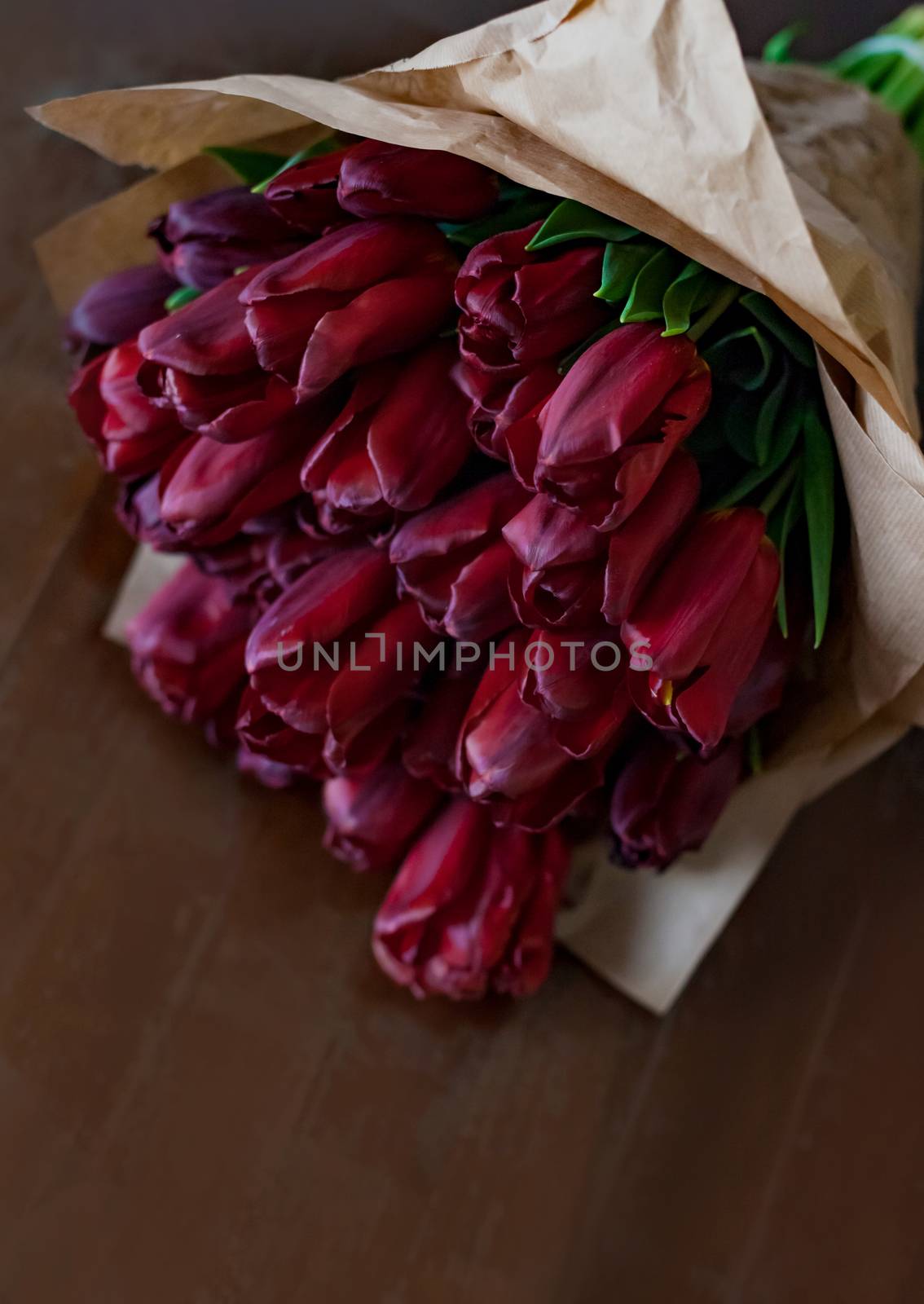 Deep red tulip bouquet on wooden background