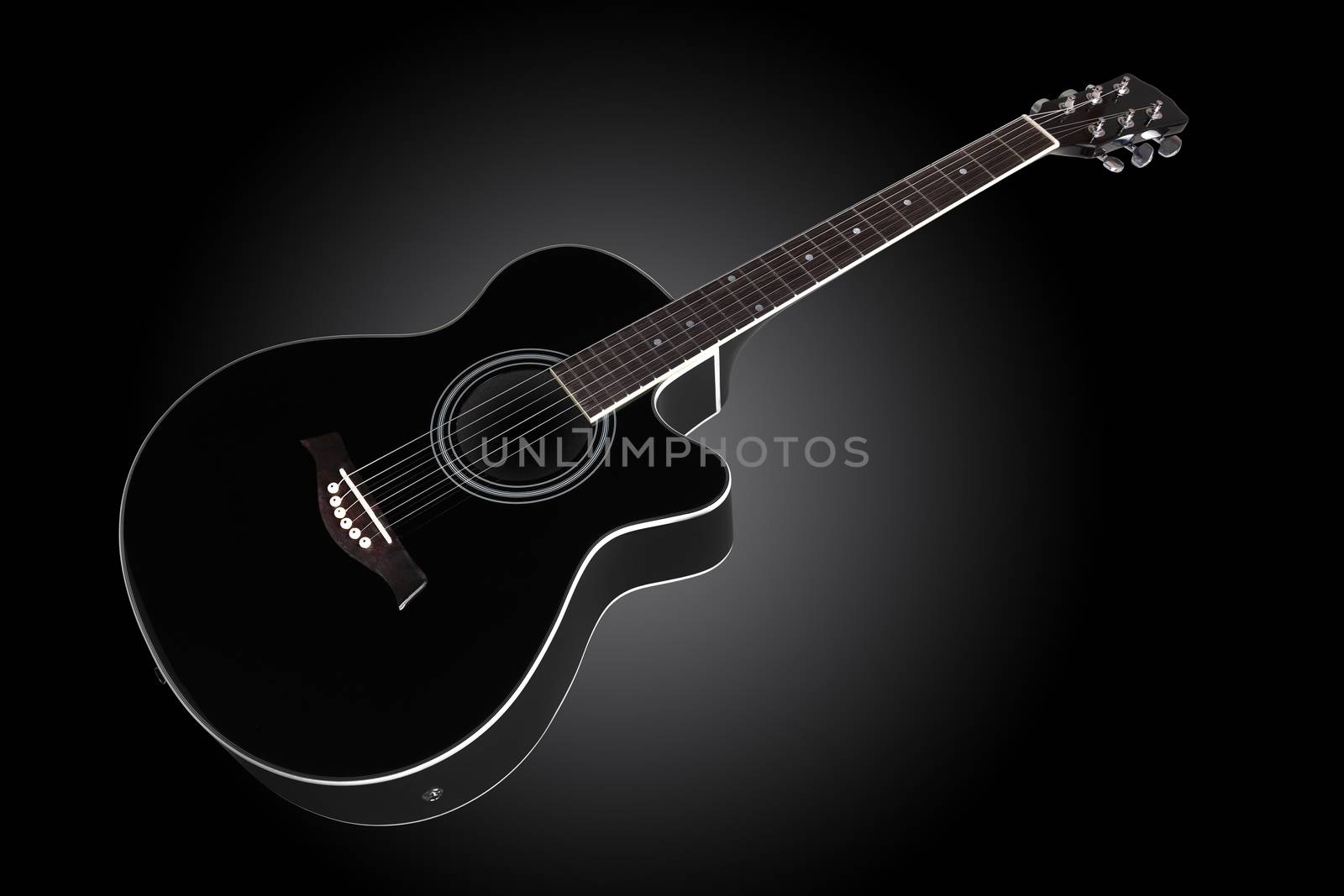 guitar inclined on dark graduated background with copy space by VivacityImages