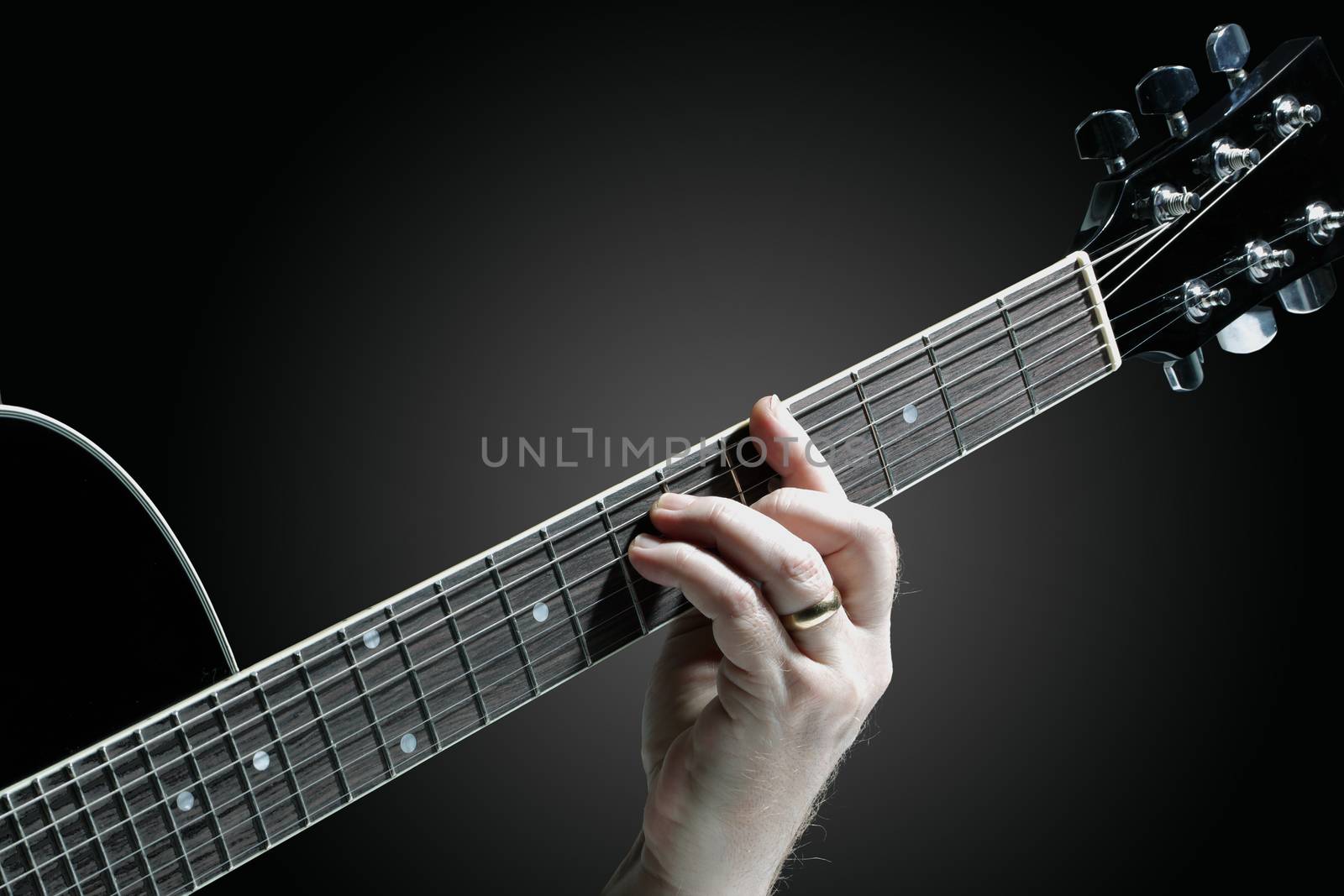 A Musician playing guitar on a dark graduated background