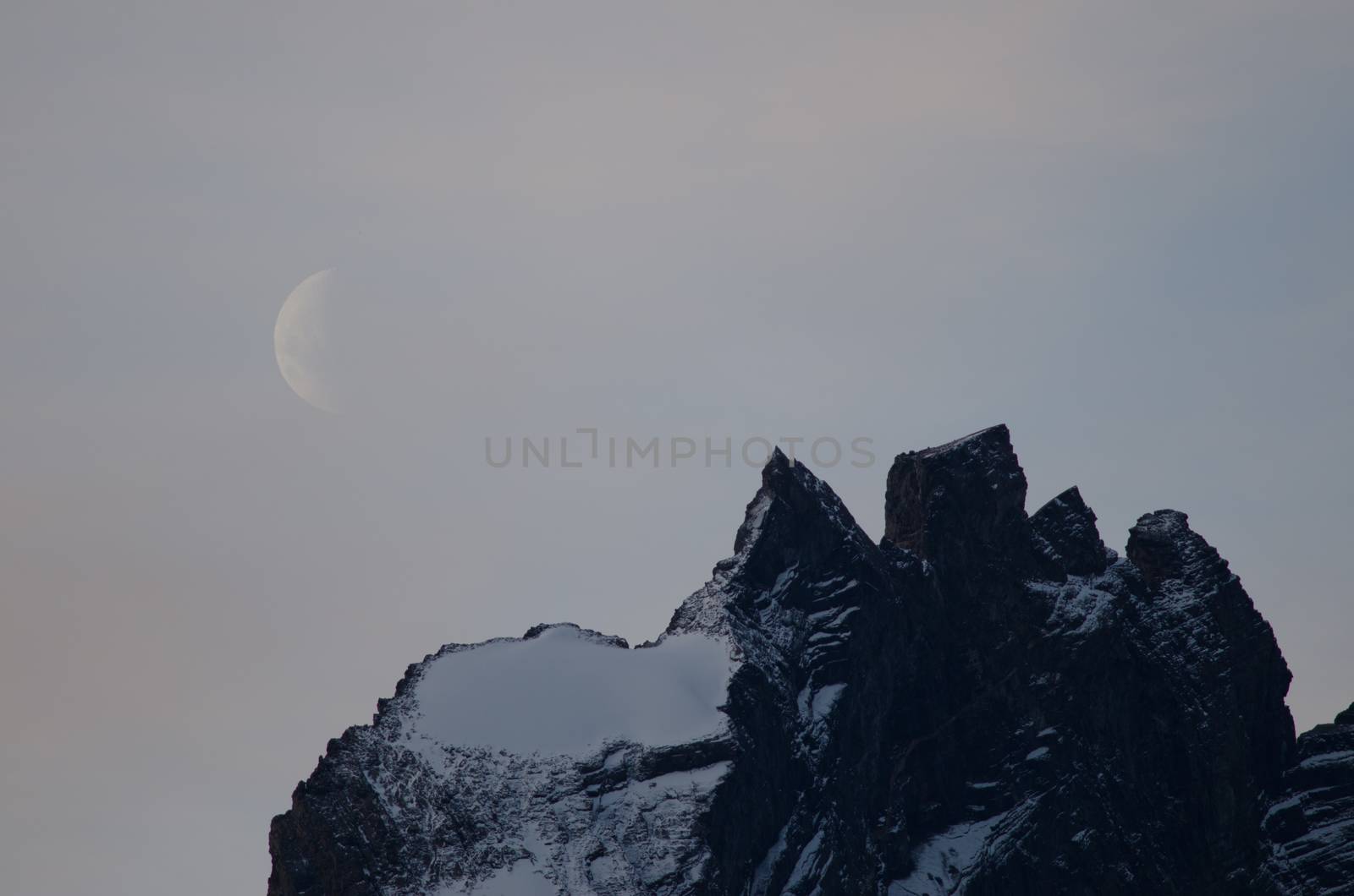 Moon on a cliff in the Torres del Paine National Park. by VictorSuarez