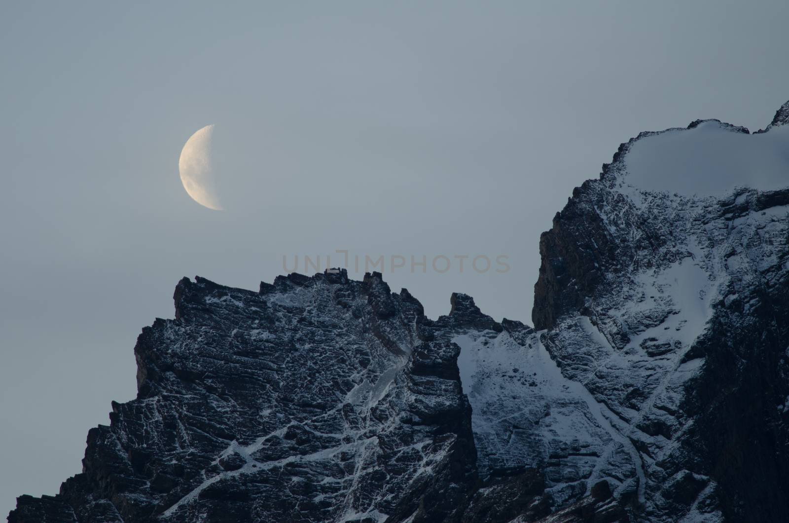Moon on a cliff in the Torres del Paine National Park. by VictorSuarez