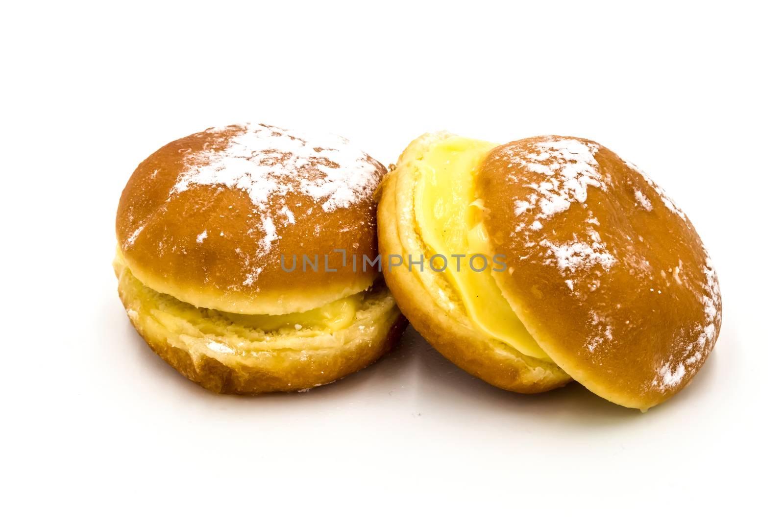 Bola de Berlim, or Berlim Ball, a Portuguese pastry made from a fried donut filled with sweet eggy cream and rolled in crunchy sugar on a white background.