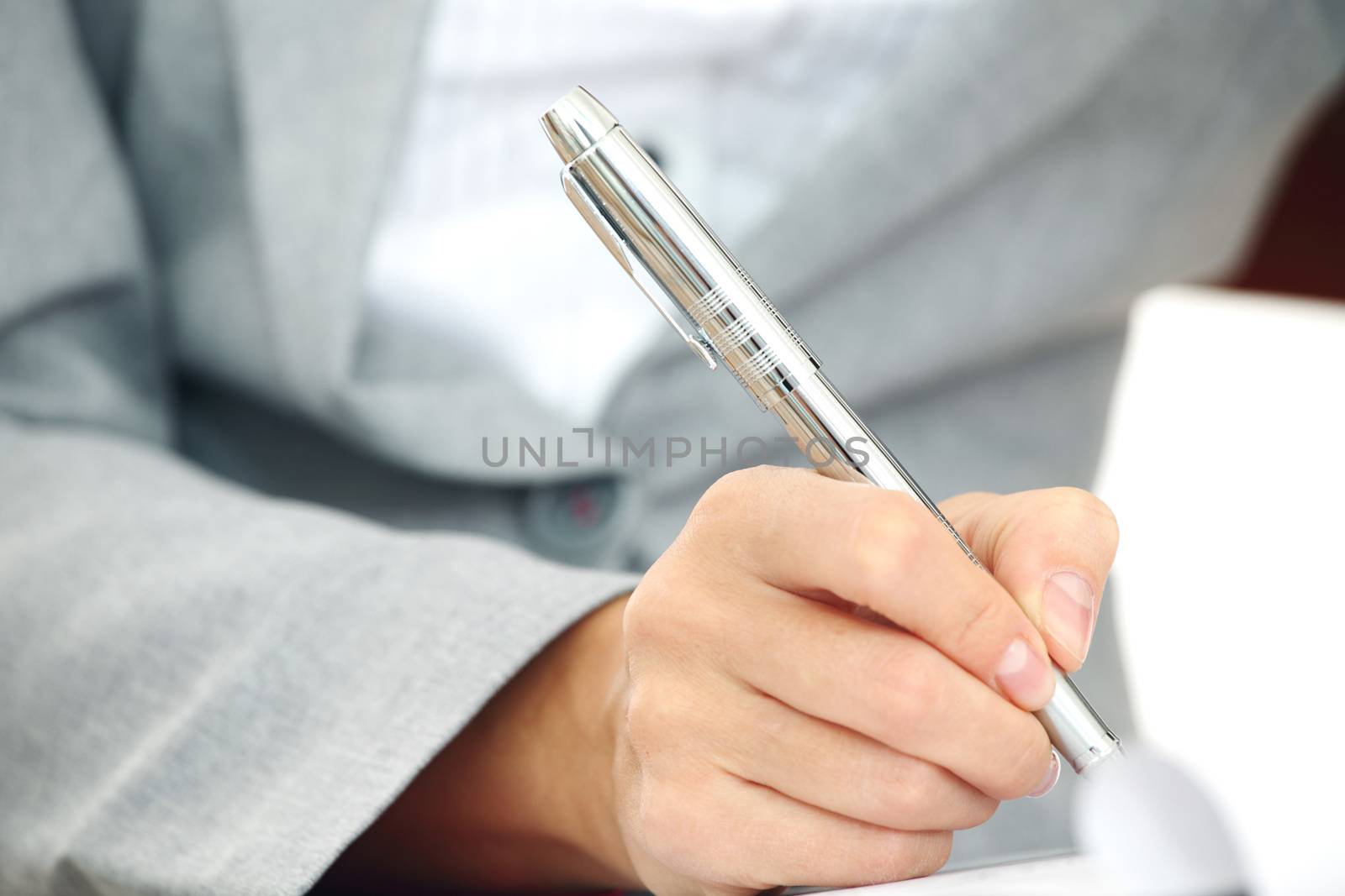 Business woman in suit signing contract with pen, document, paperwork