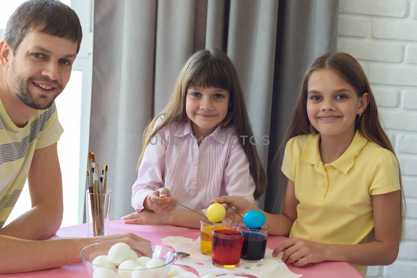 The children, together with dad, painted the first Easter eggs and looked joyfully into the frame by Madhourse