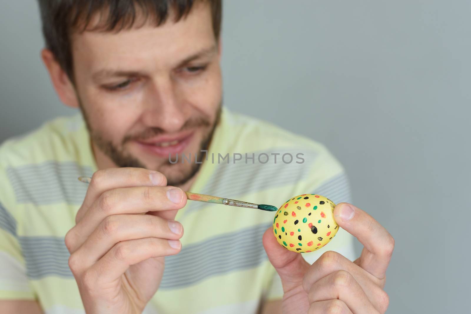 Man paints an egg for Easter