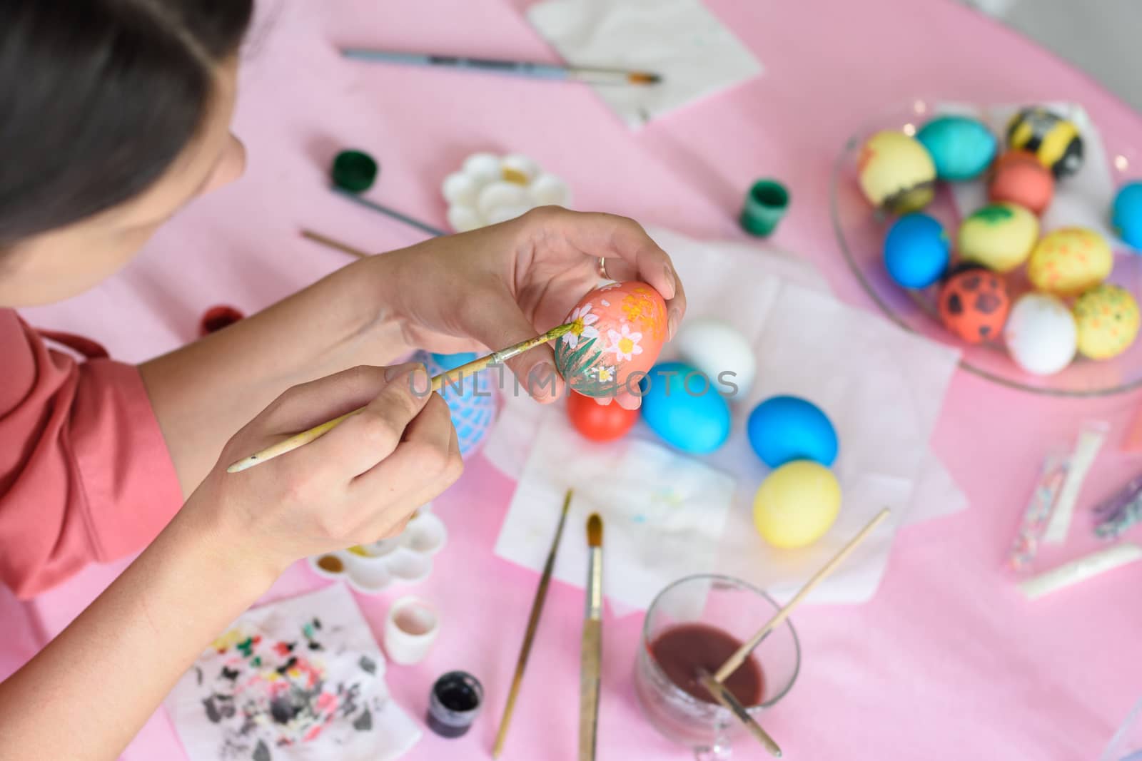 Girl paints chicken eggs for Easter by Madhourse