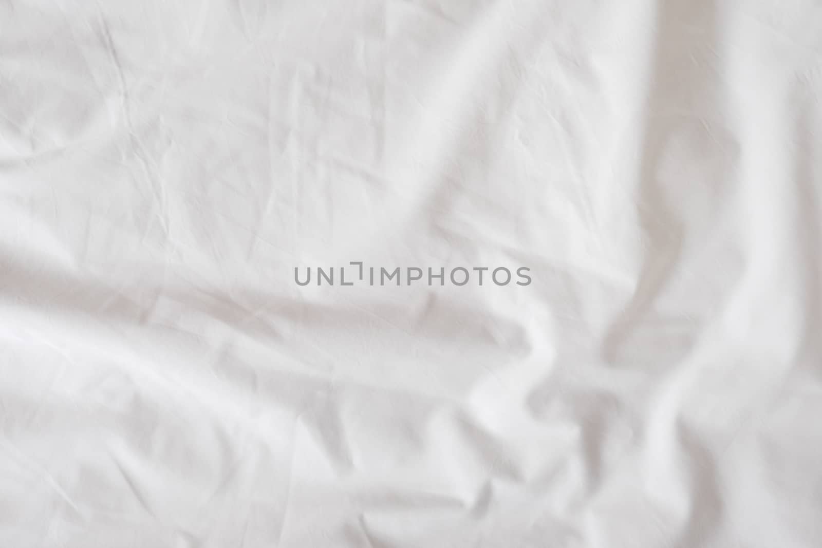 Background of white rumpled sheets. Bed linen with wrinkles in day light. Horizontal. Copy spase. Concept of rest, awakening, sleep, stay at home. For social media, blog.